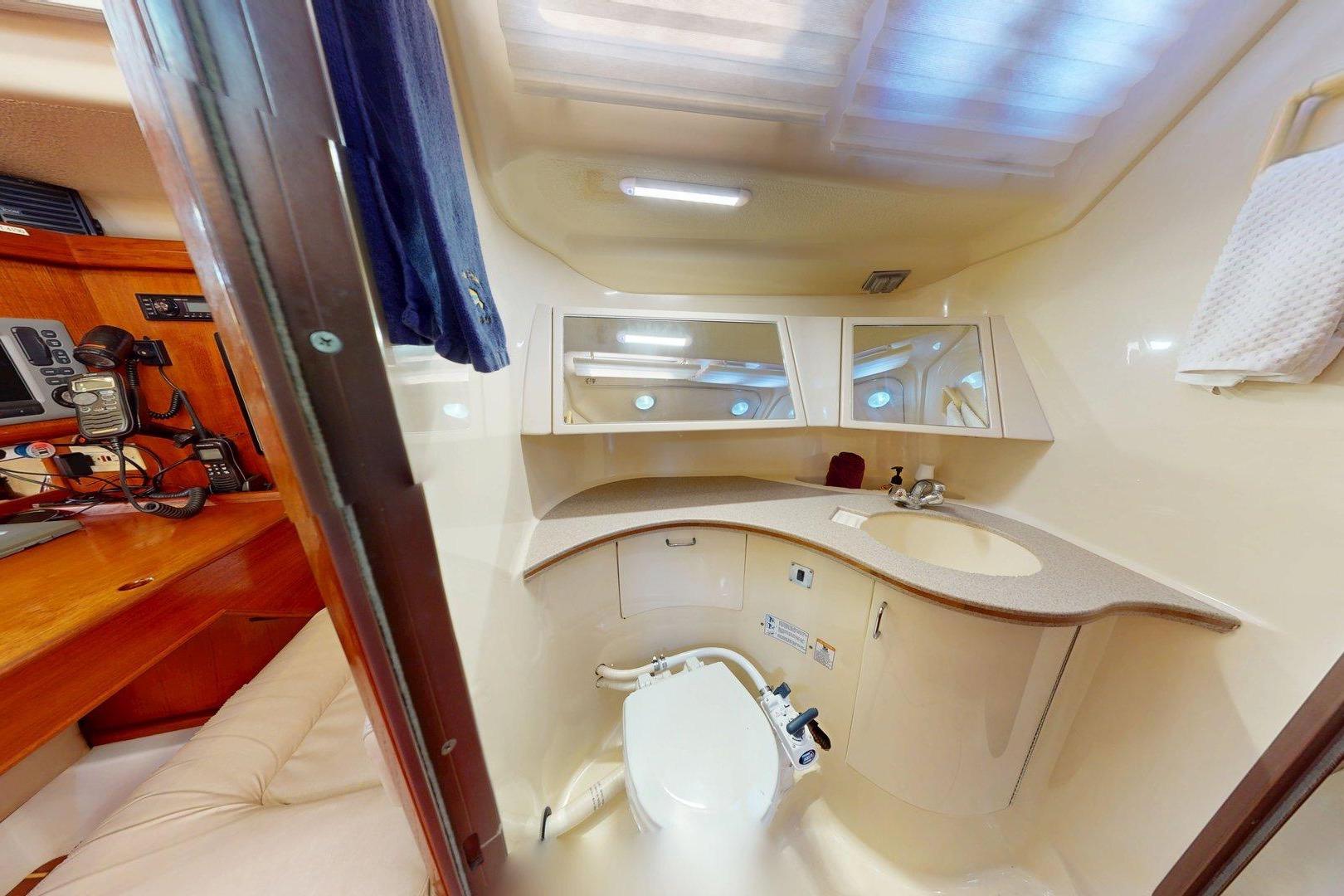 Interior of 1997 Hunter Legend 40.5 yacht bathroom with sink, toilet, and storage cabinets.