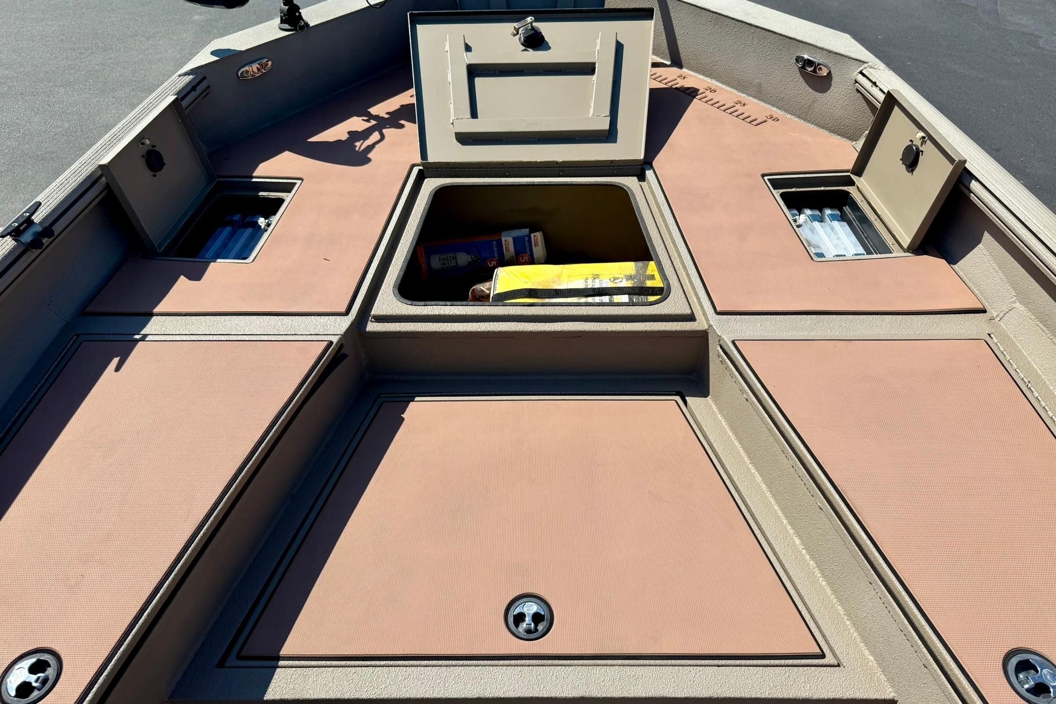 2019 Excel 230 Bay Pro boat deck with open storage compartments.
