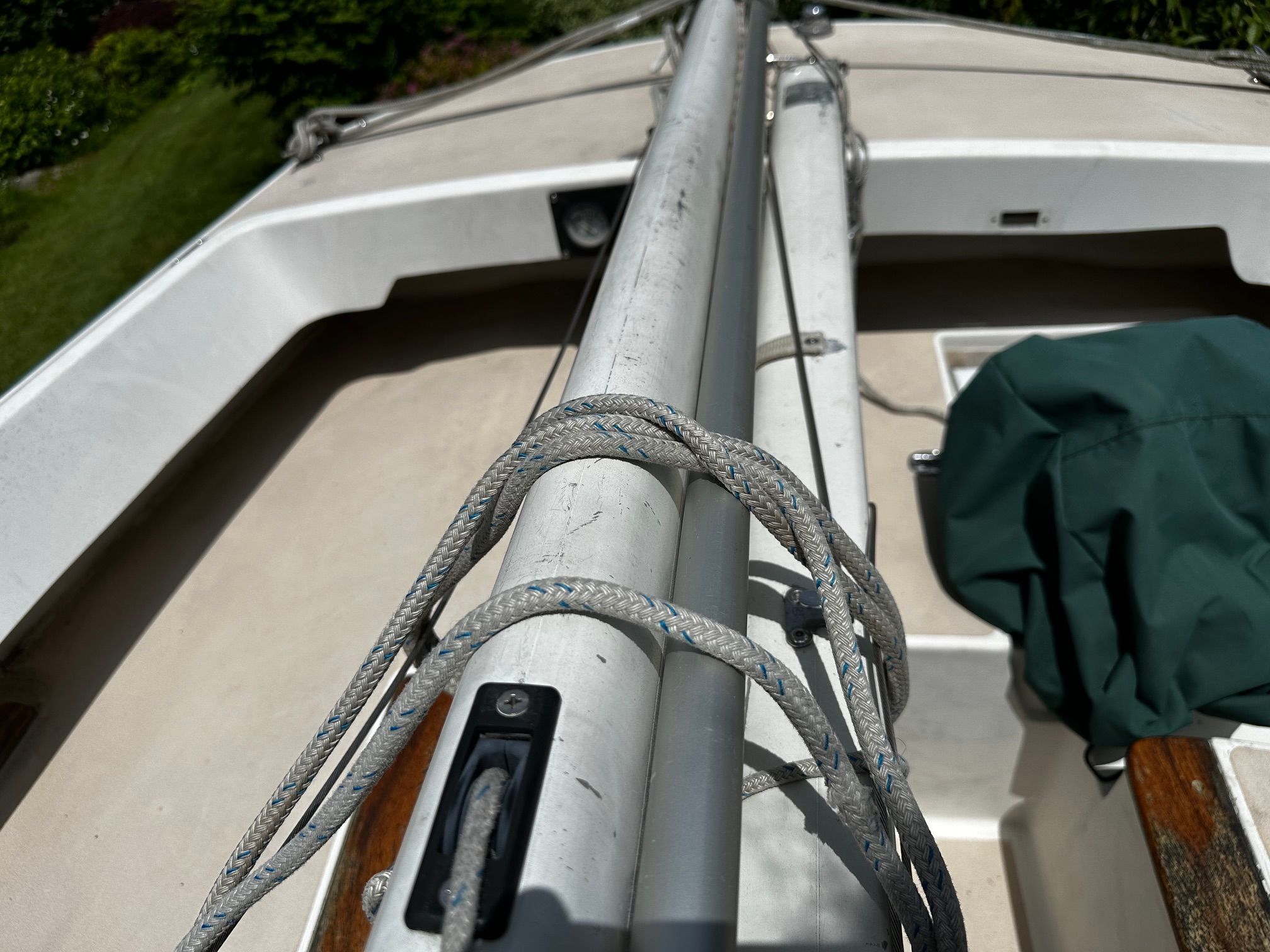 Close-up of a sailboat deck with mast and ropes.
