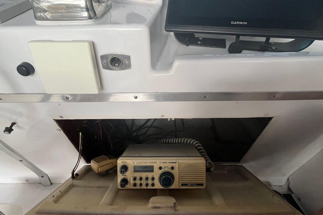 1976 Uniflite 32 Sport Sedan dashboard with marine radio and Garmin display.