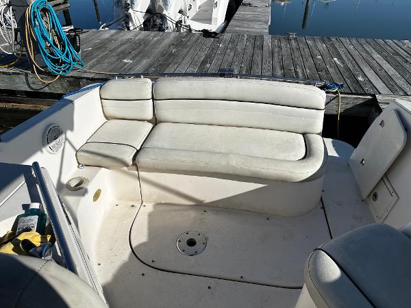 2004 Rinker Fiesta Vee 250 boat interior with white seating at dock.