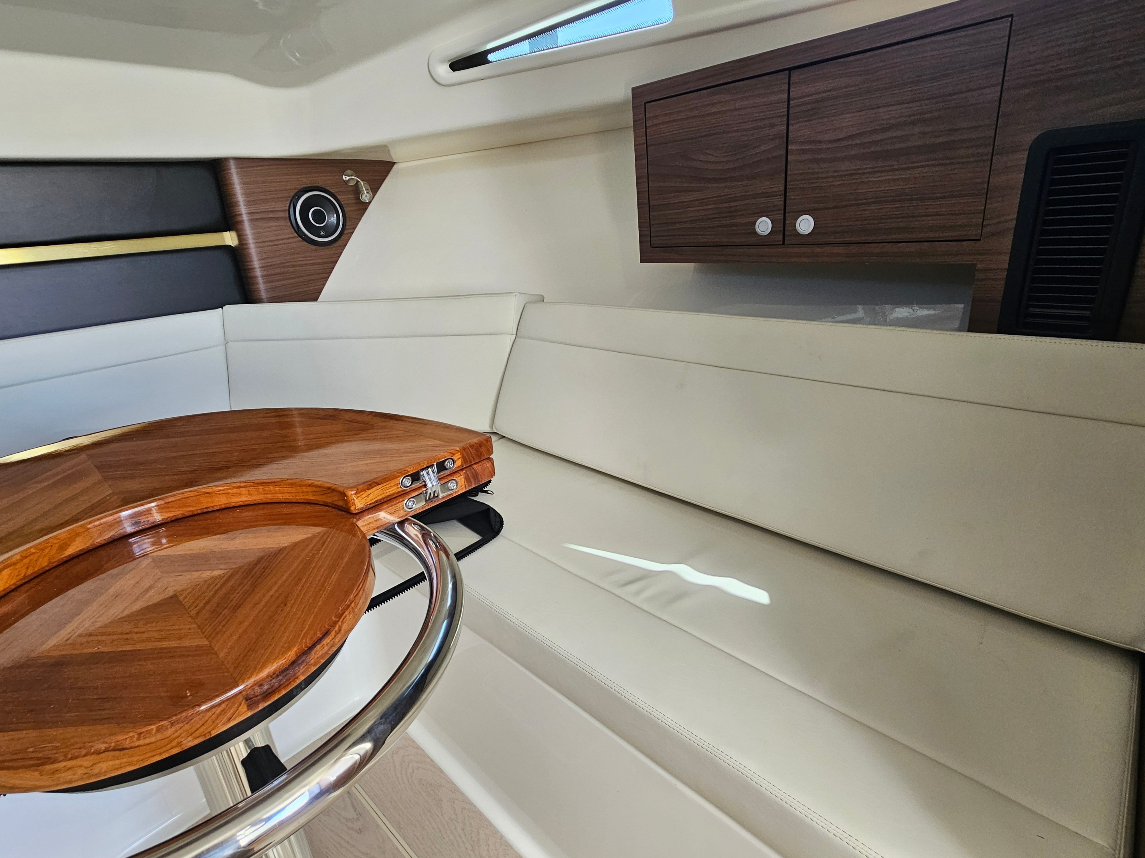 Interior of the Boston Whaler 325 Conquest with sleek wood paneling and beige upholstery.