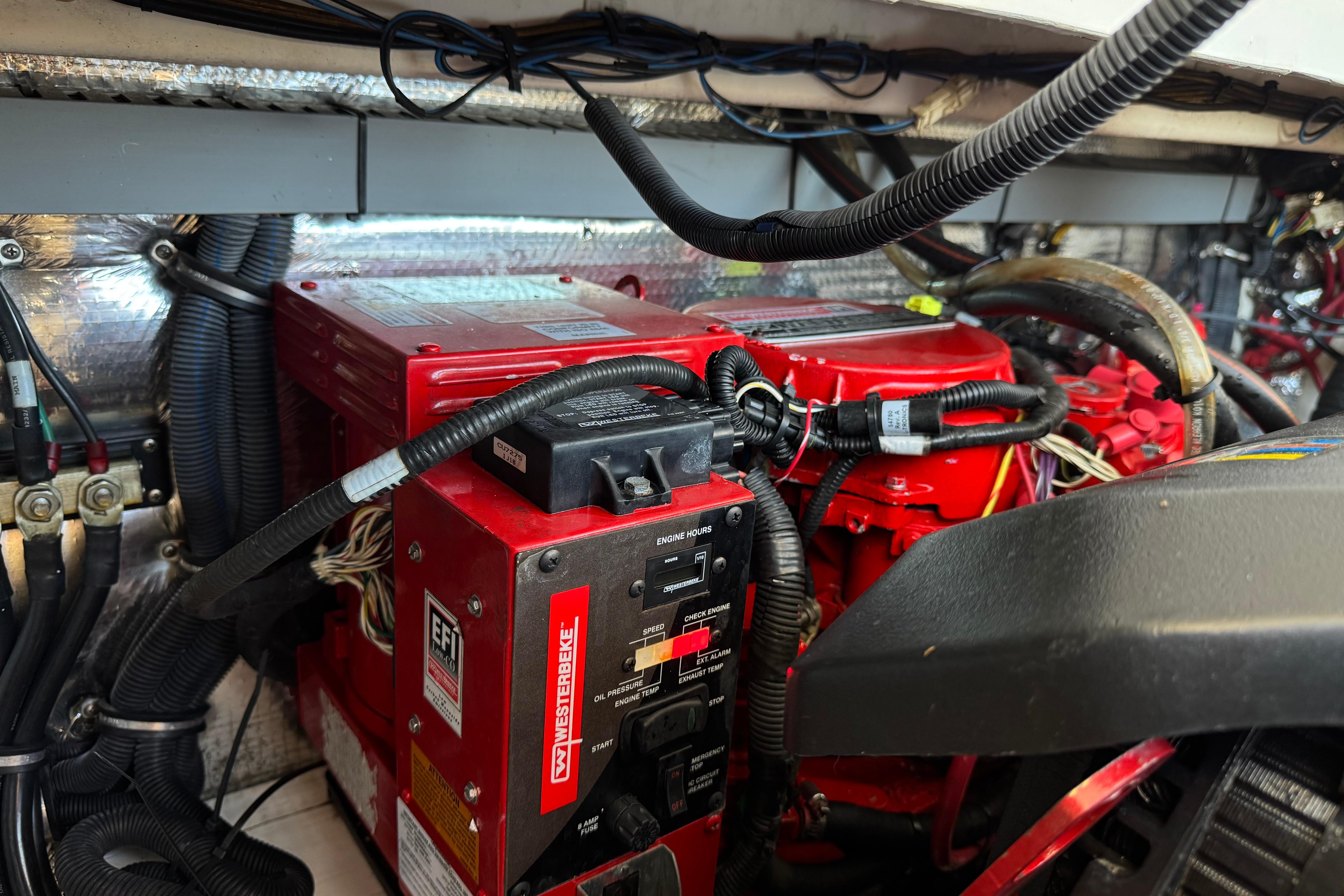 Engine compartment of a 2013 Regal 28 Express boat with red machinery and wiring.