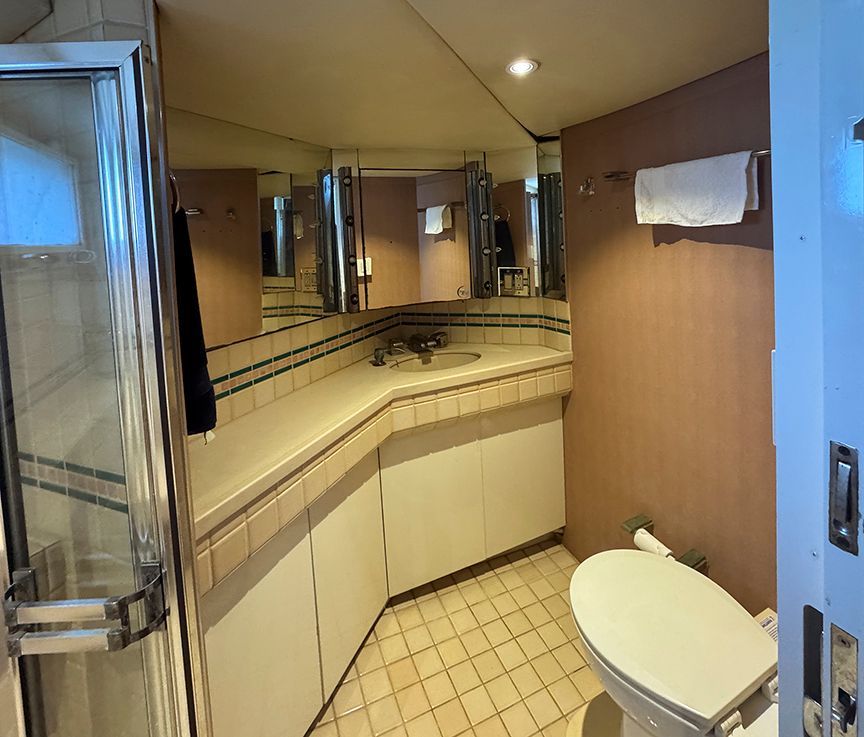 The image shows a yacht bathroom with a shower, sink, and toilet.