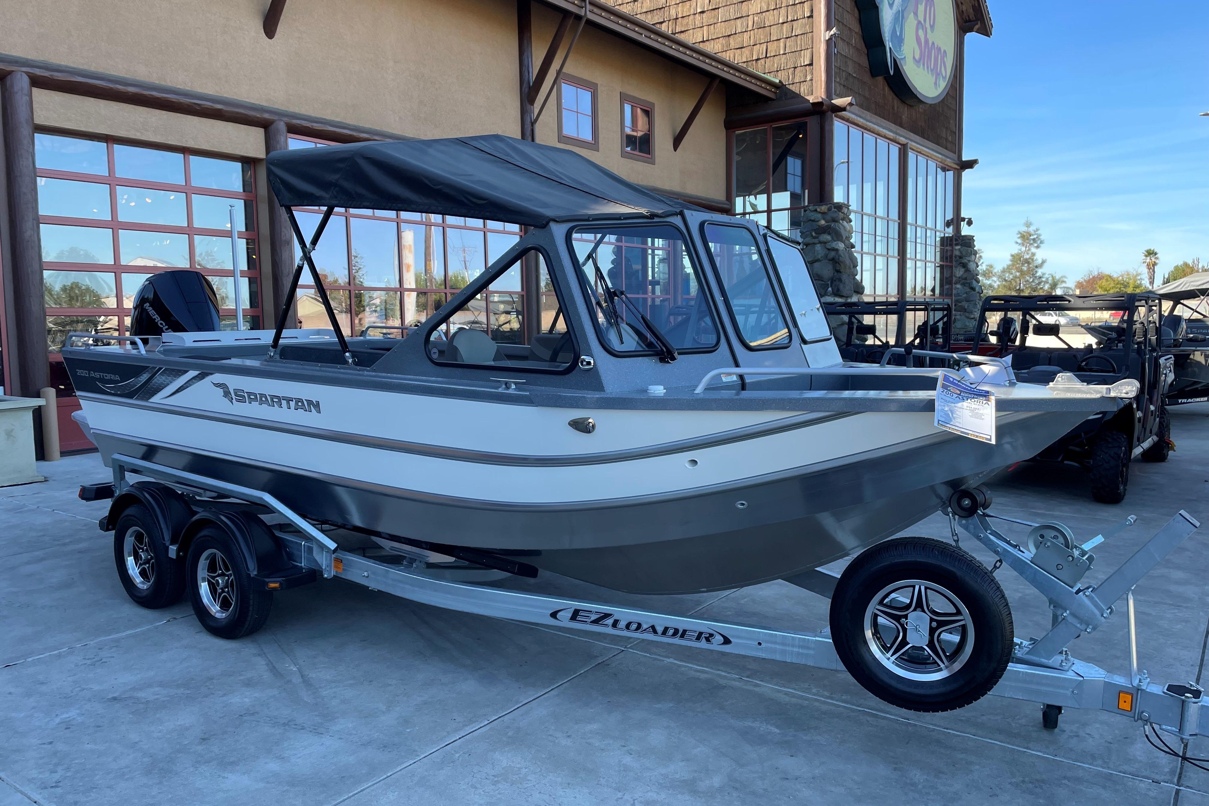 2025 Spartan 200 Astoria boat on trailer outside a building.