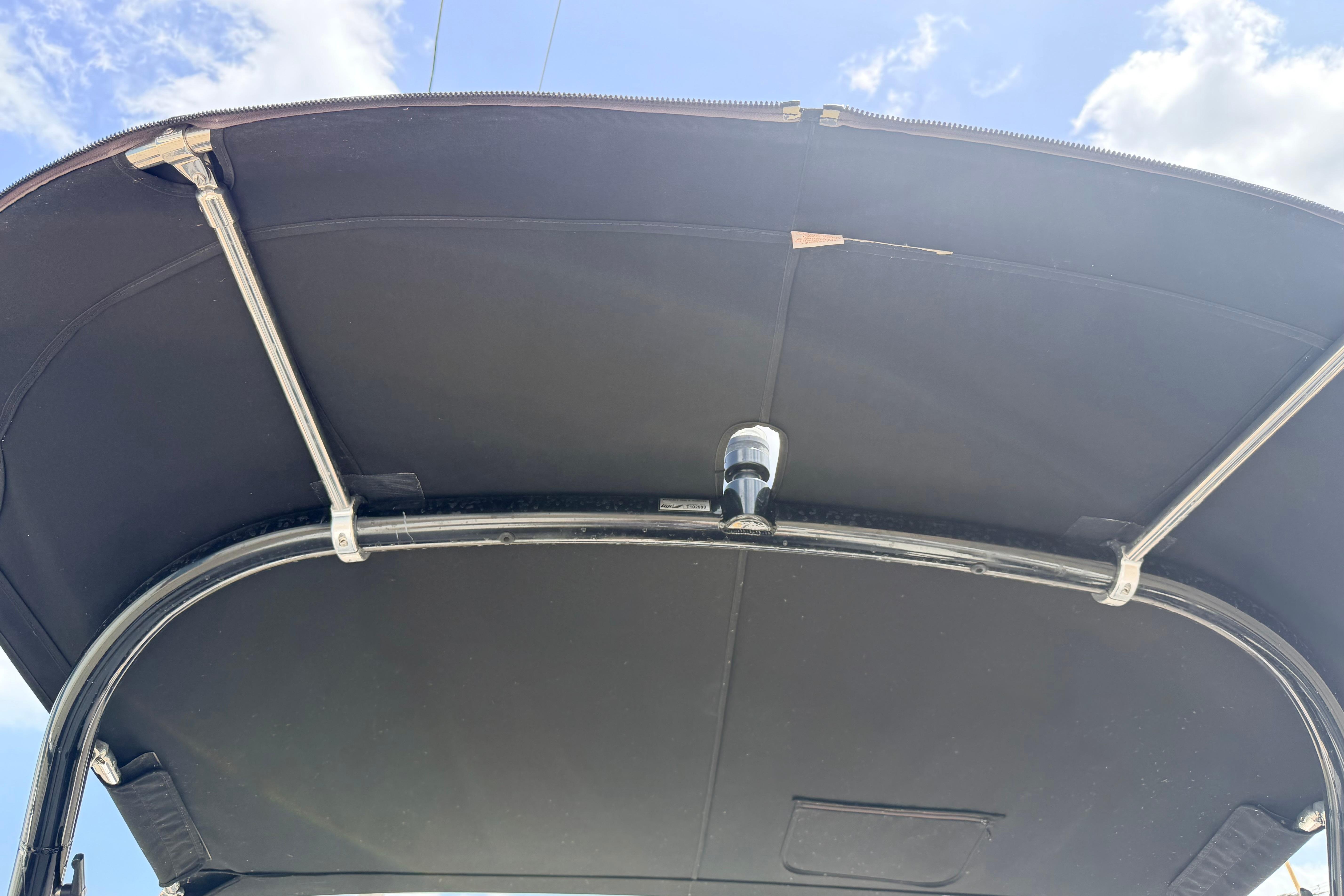 2014 Tigé R20 boat canopy with metal frame under a blue sky.