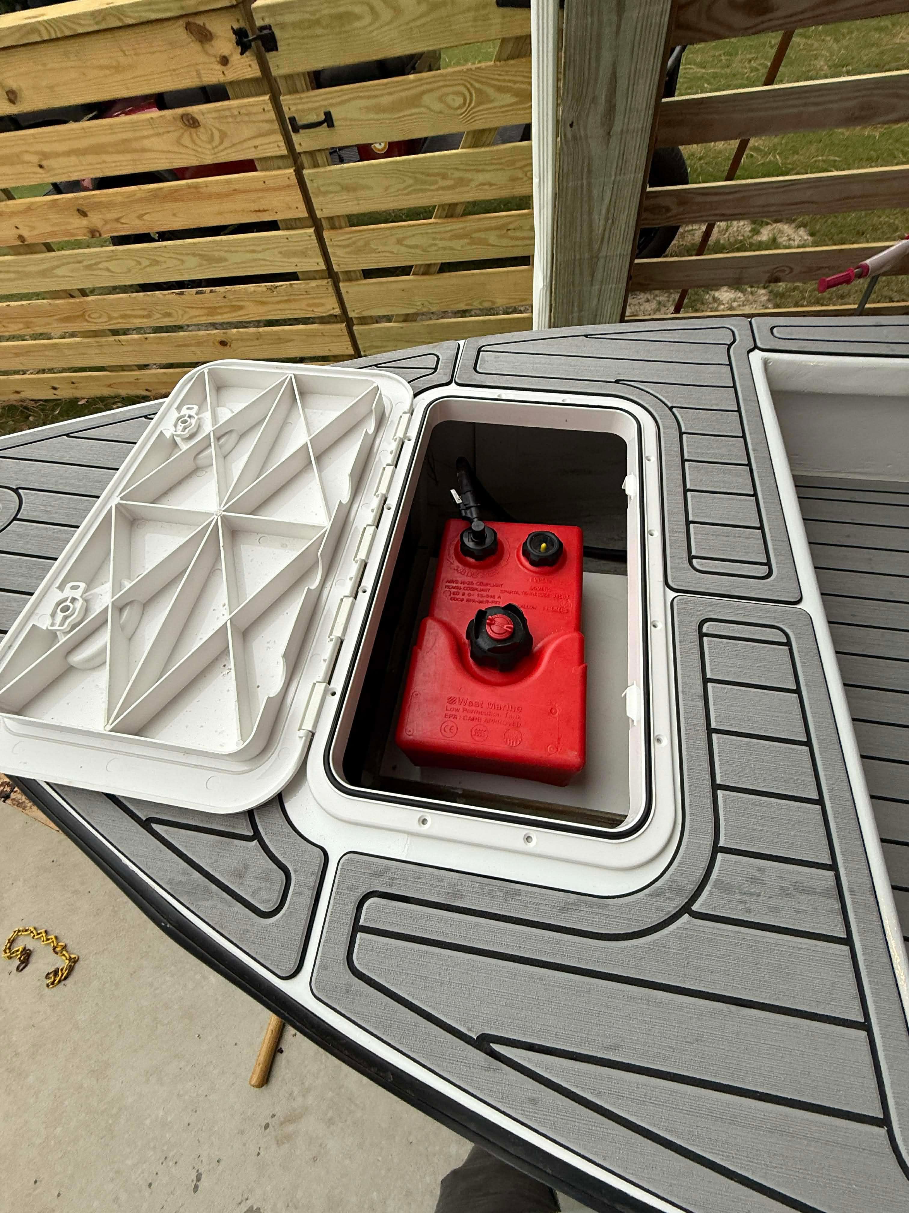 Skiff Craft boat with open storage compartment and red canister.