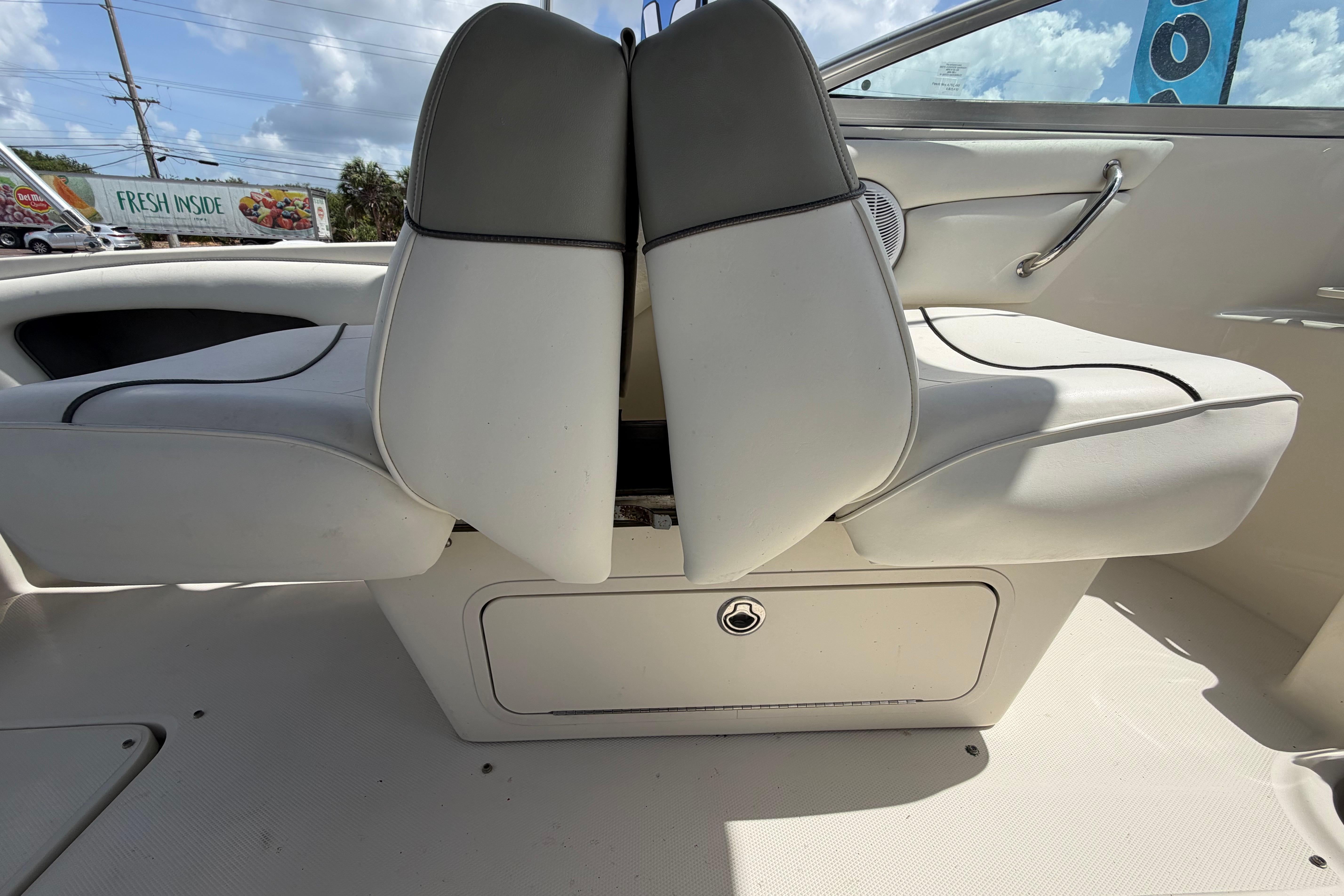 2006 Sea Ray 250 Amberjack boat interior with white seating and storage compartment.