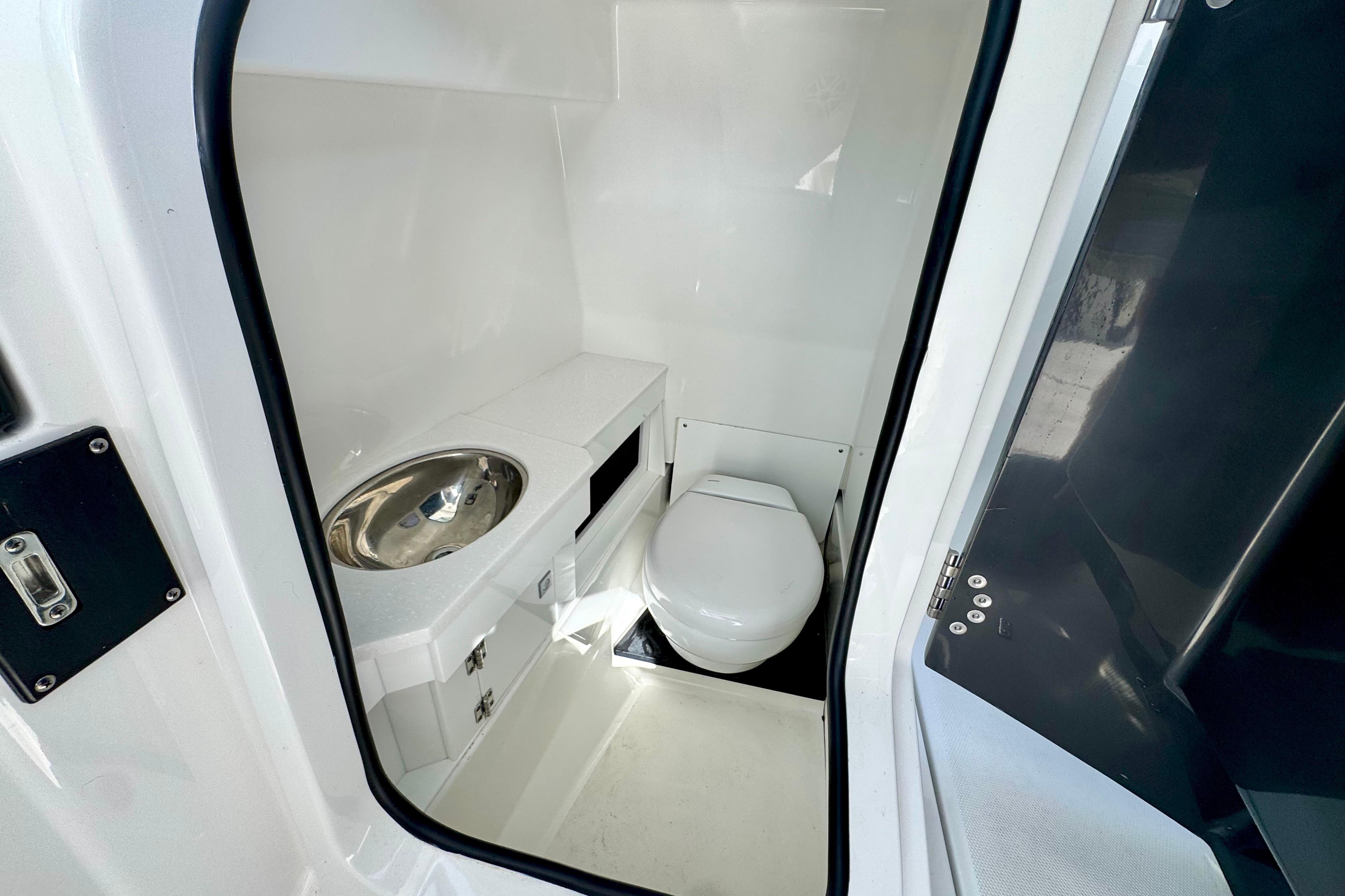 2023 Blackfin 272 DC boat interior with compact bathroom and stainless steel sink.