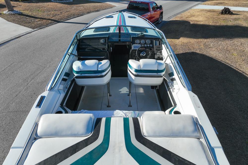 1989 Formula 292 SR-1 boat interior with striped seats and dashboard, parked near a red truck.