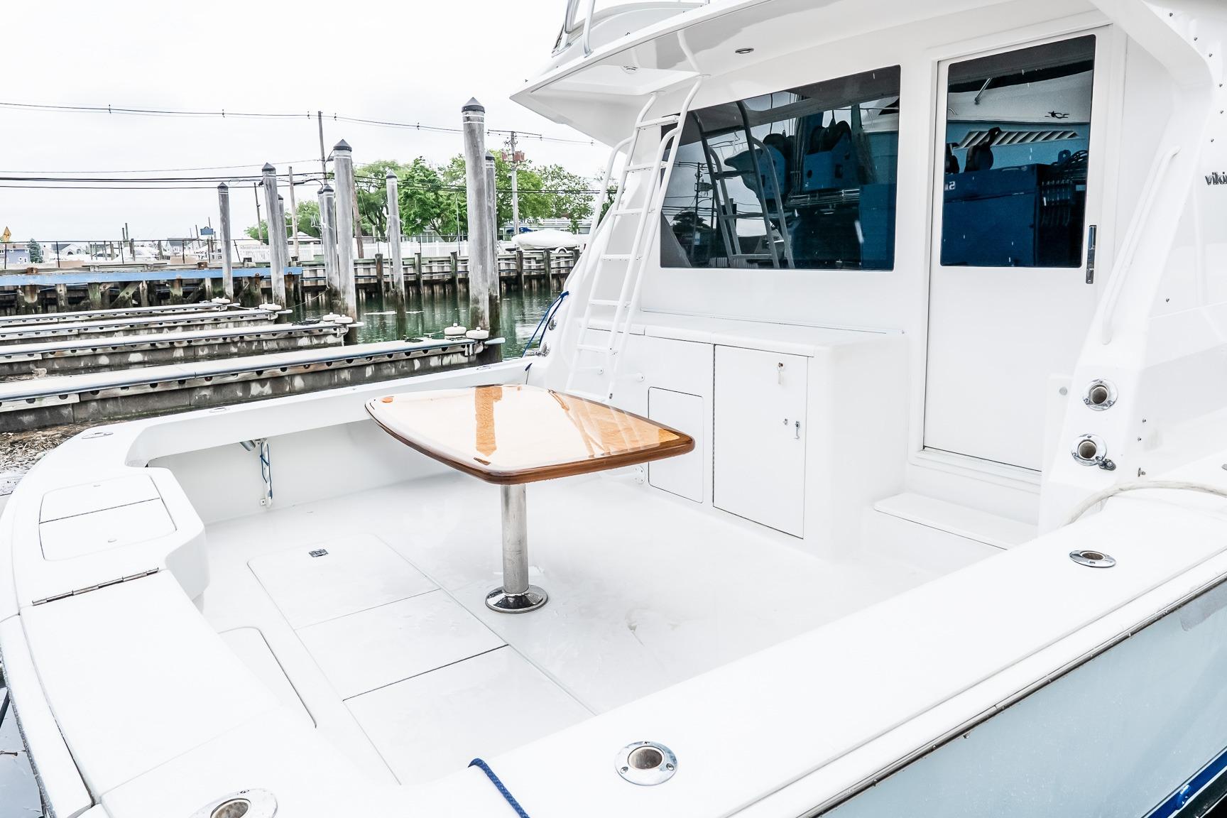 Viking 50' Convertible 2000 yacht cockpit with table, docked at marina.