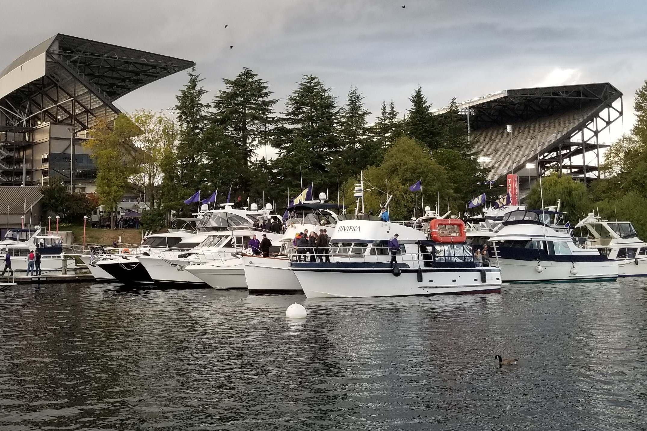 Boats docked near a stadium, featuring a 1964 Grandy Tour Boat.