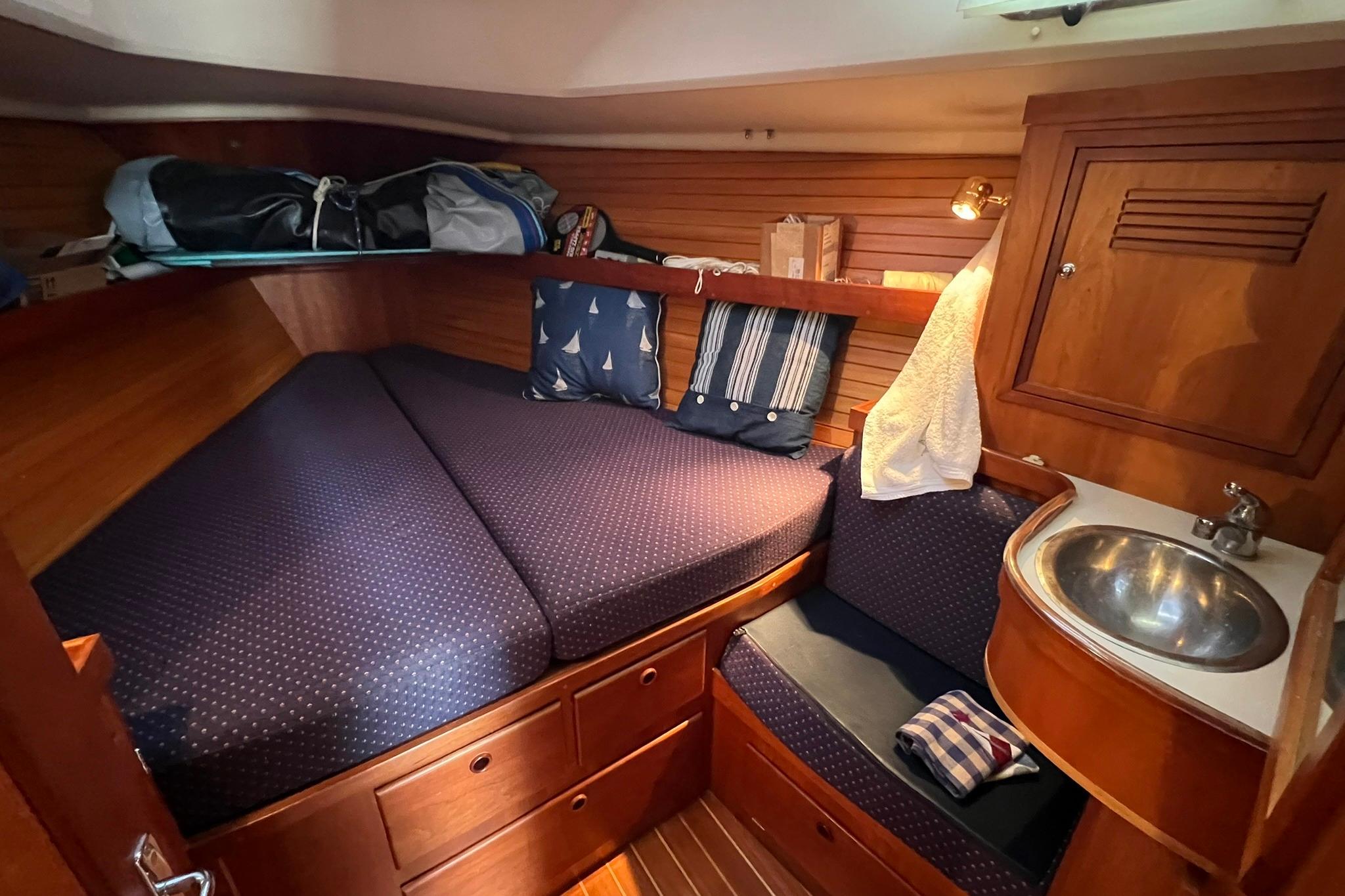 Cozy cabin interior of 1998 Sabre 362 sailboat with bed, sink, and storage.