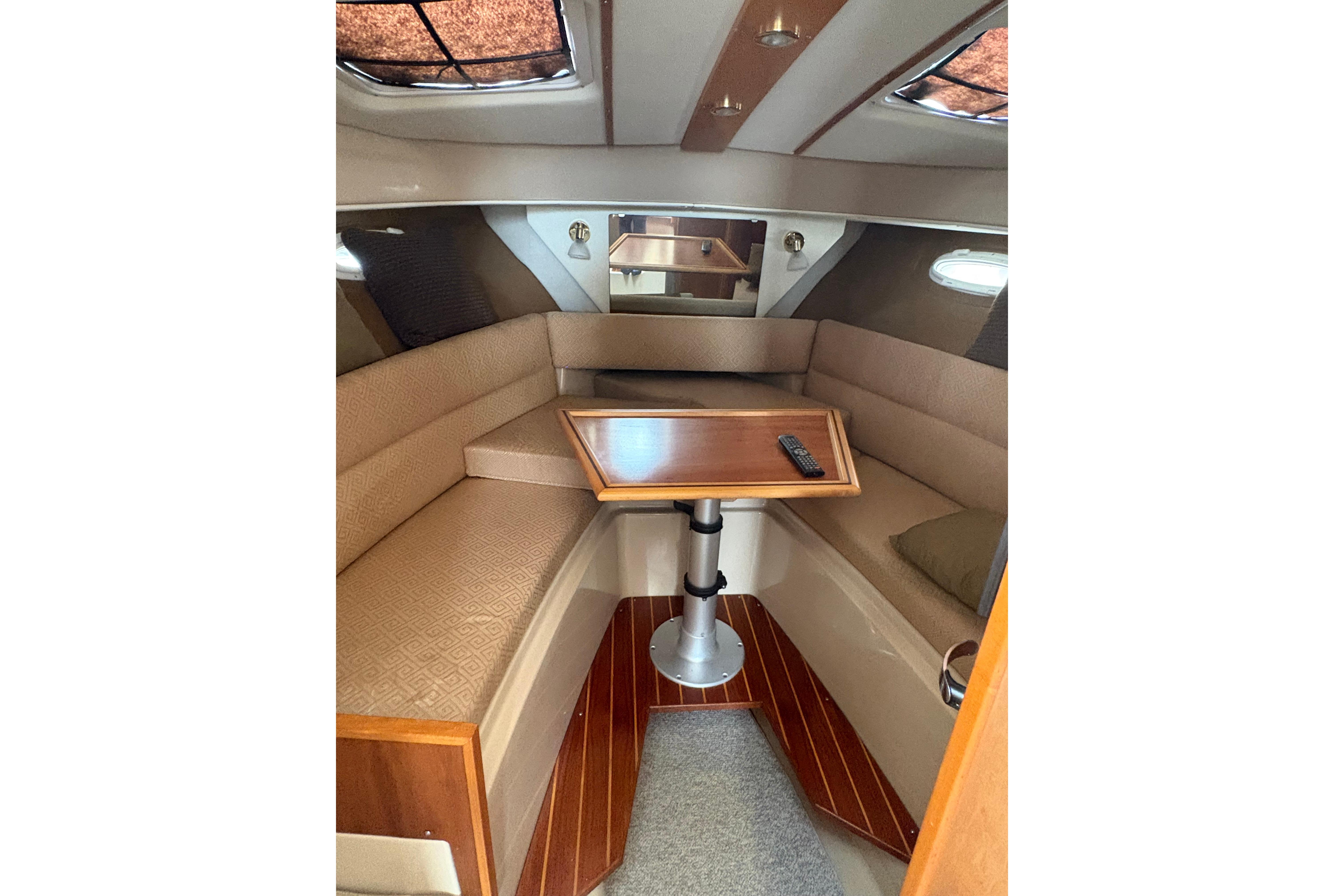 Interior of 2012 Cutwater C-26 boat with cozy seating and wooden table.
