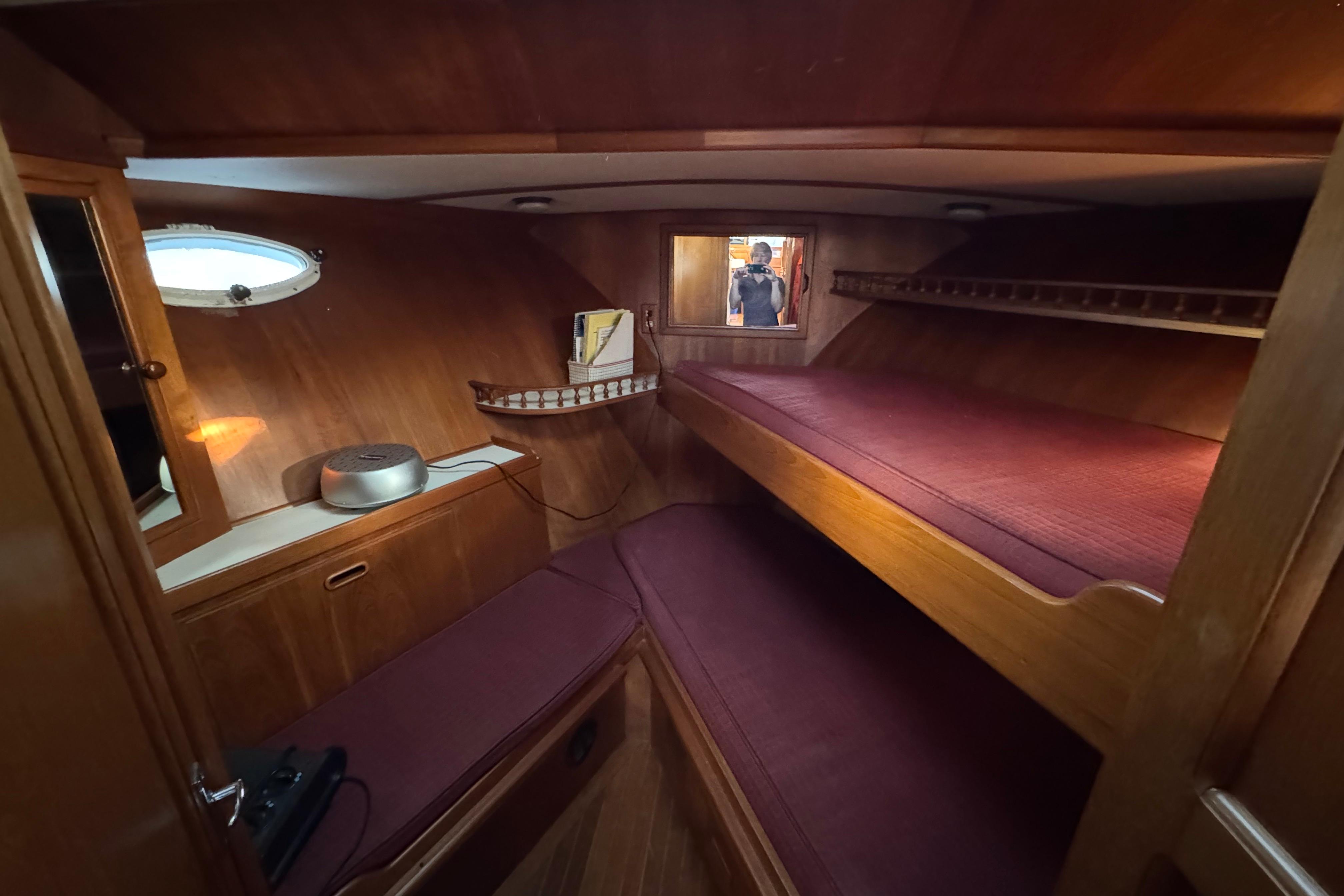 Cozy cabin interior of 1987 President 37 yacht with wooden furnishings and bunk beds.