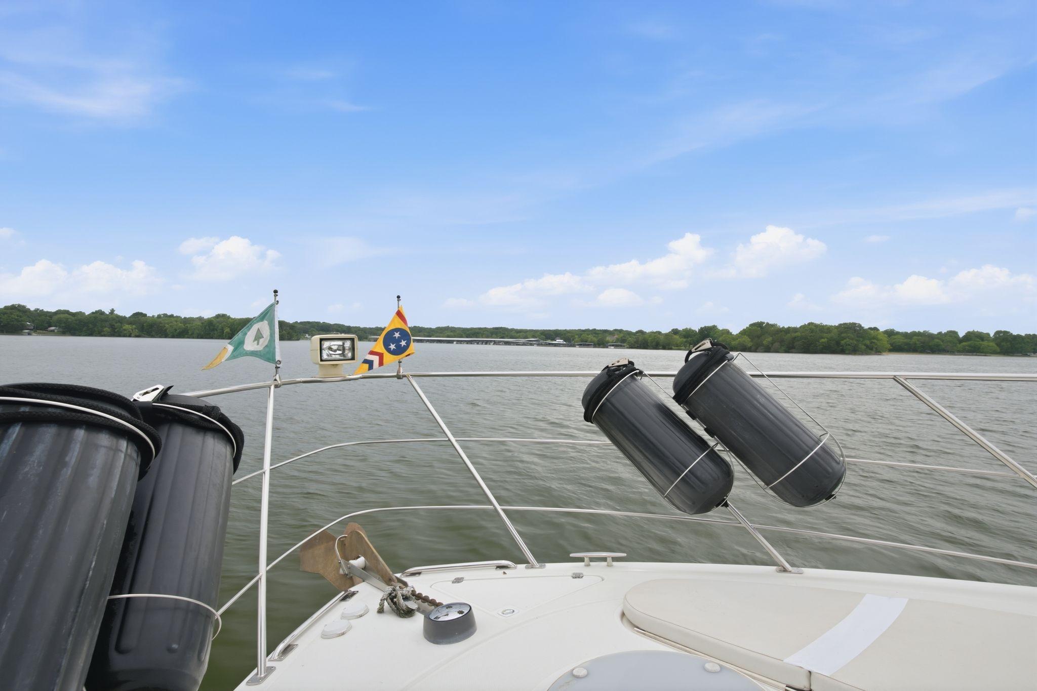 2005 Carver 39 Motor Yacht on a serene lake with clear skies and flags.
