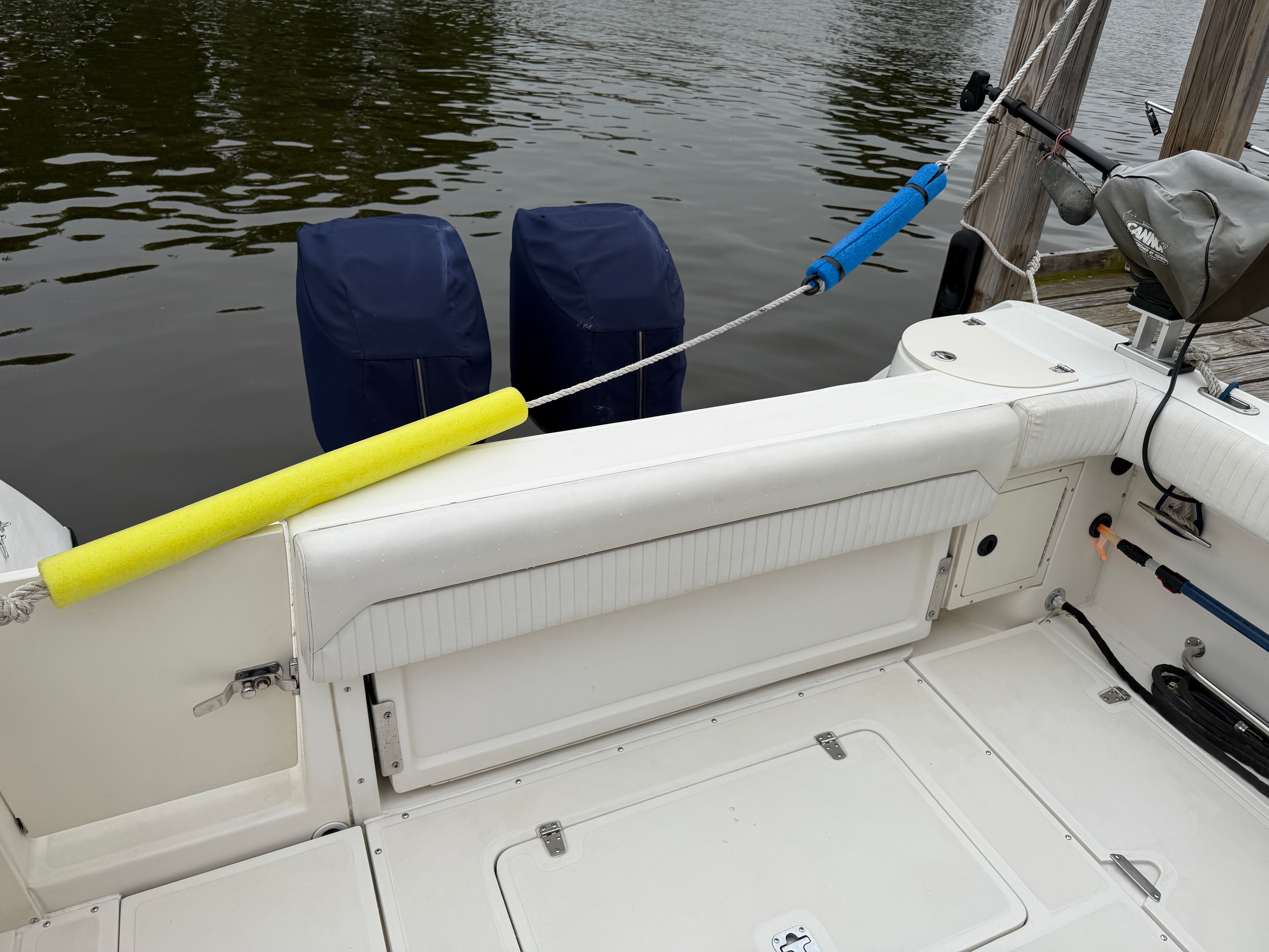 The image shows the stern of a Boston Whaler 26 Conquest boat at a dock.