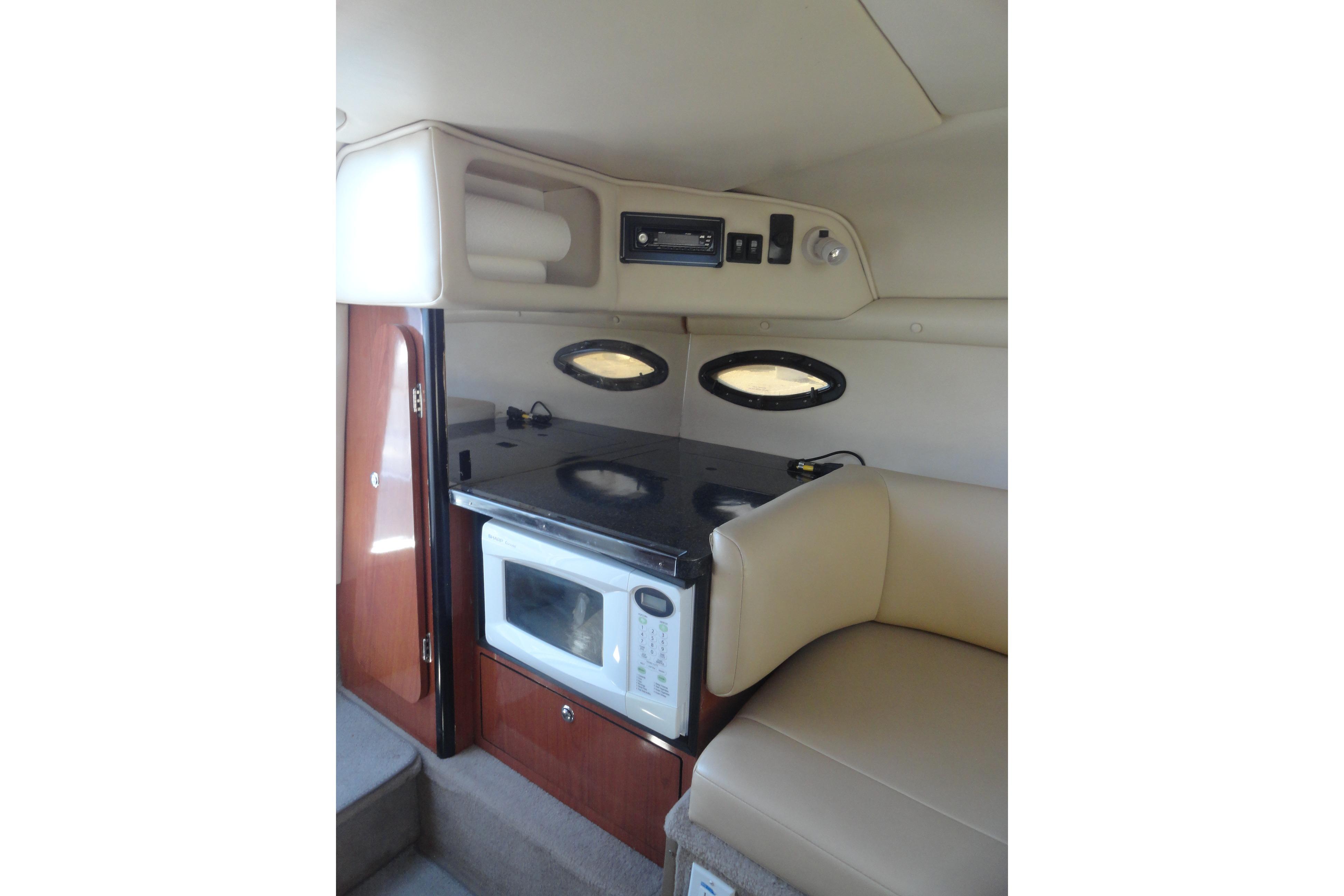 2001 Chaparral 265 SSi boat interior with kitchenette, microwave, and seating area.