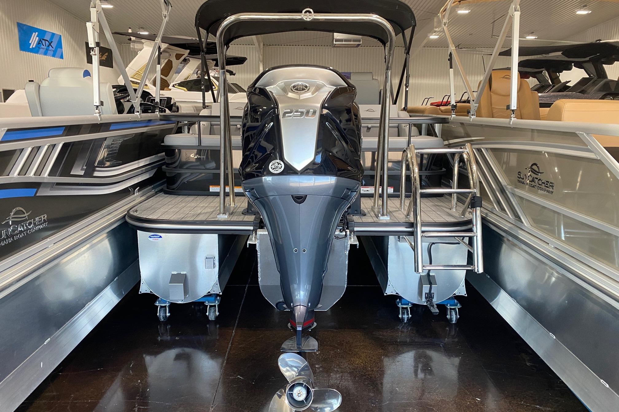 2026 SunCatcher Fusion 324SS pontoon boat with powerful outboard motor in showroom.