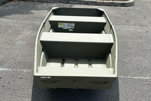 2026 Tracker Grizzly 12 Jon boat, parked on asphalt, showcasing interior seating and storage.