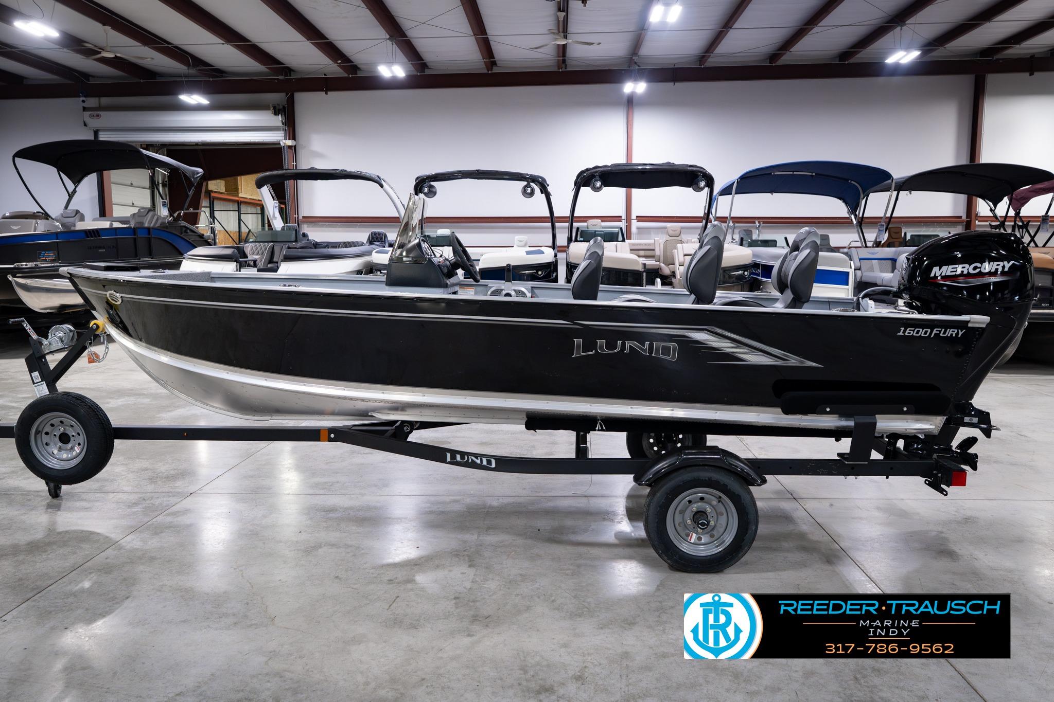 2026 Lund 1600 Fury SS boat on trailer in showroom, featuring Mercury engine.