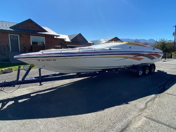 2002 Advantage Victory boat on trailer, parked in residential area, sunny day.