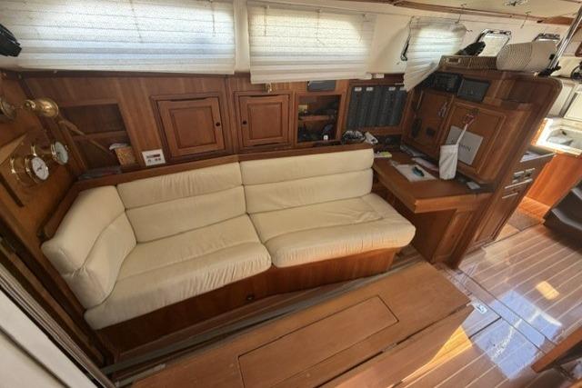Interior of 2002 Saga 43 yacht with wooden finish and cream sofa.