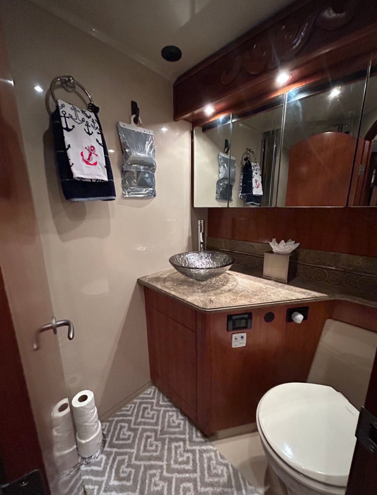 Luxurious bathroom with sink, toilet, and mirror inside a yacht.