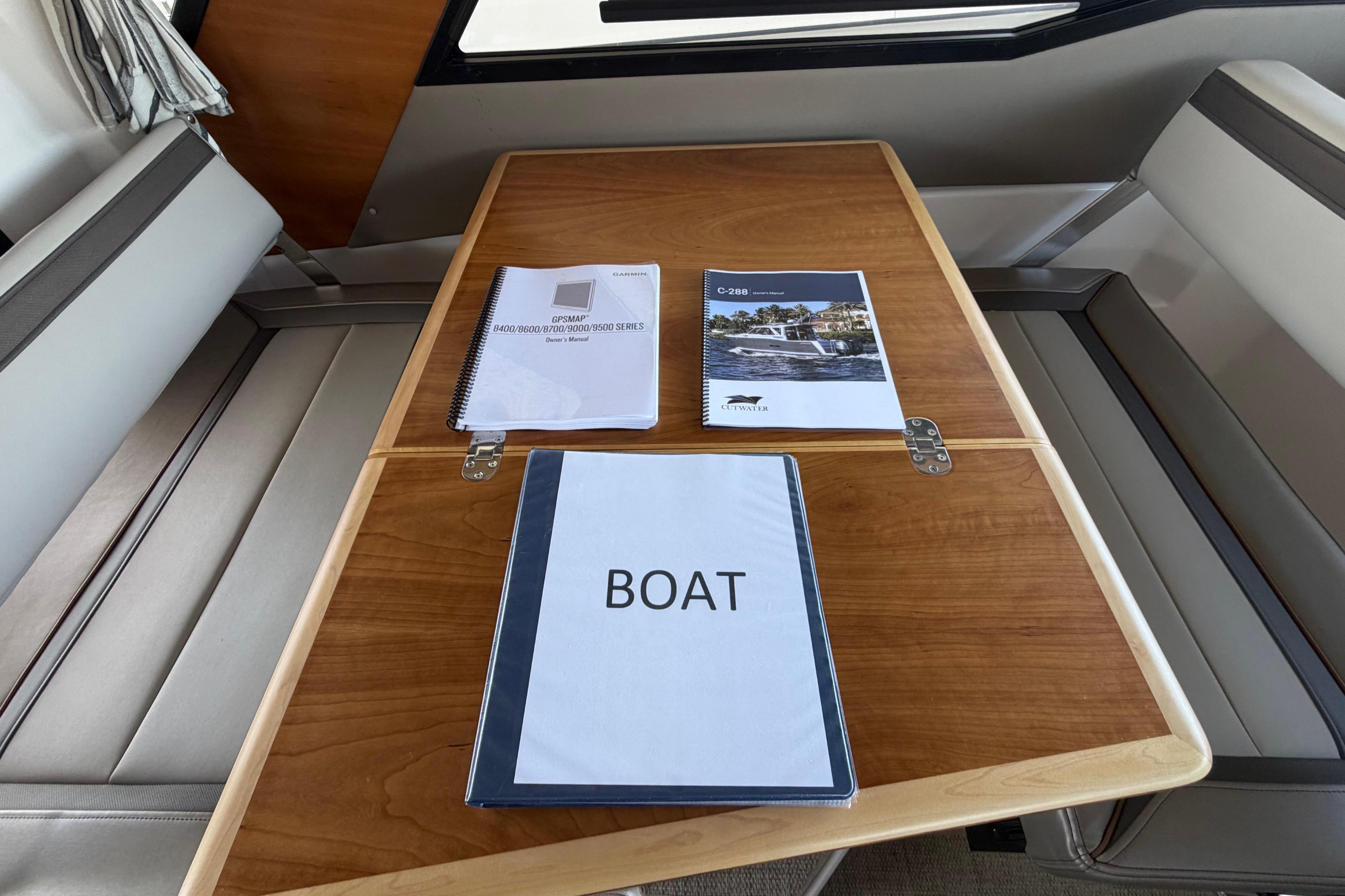 2023 Cutwater C-288 Coupe interior with manuals on a wooden table.