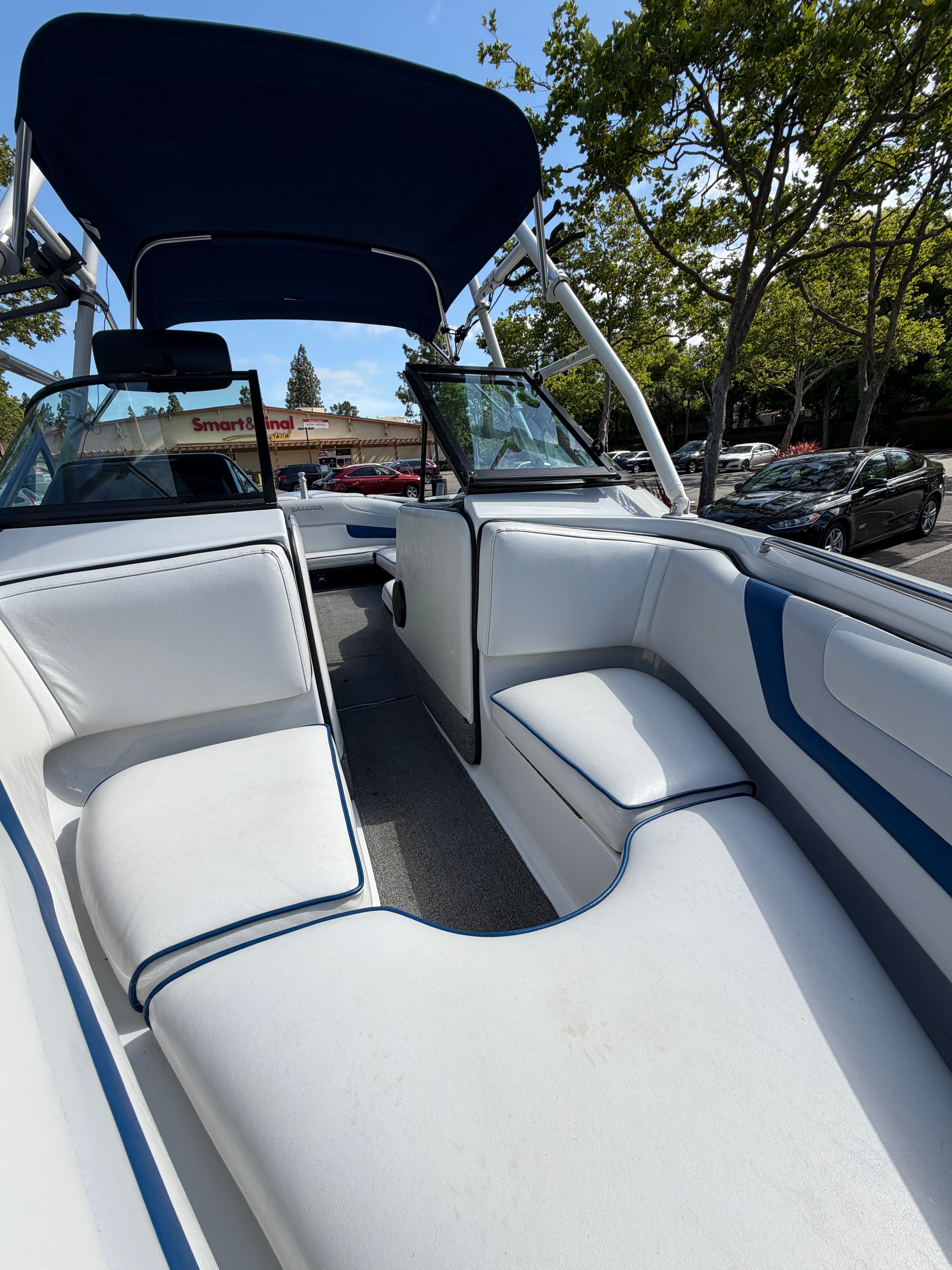 Interior view of a 2001 Sanger V210 boat with white seating and blue accents.