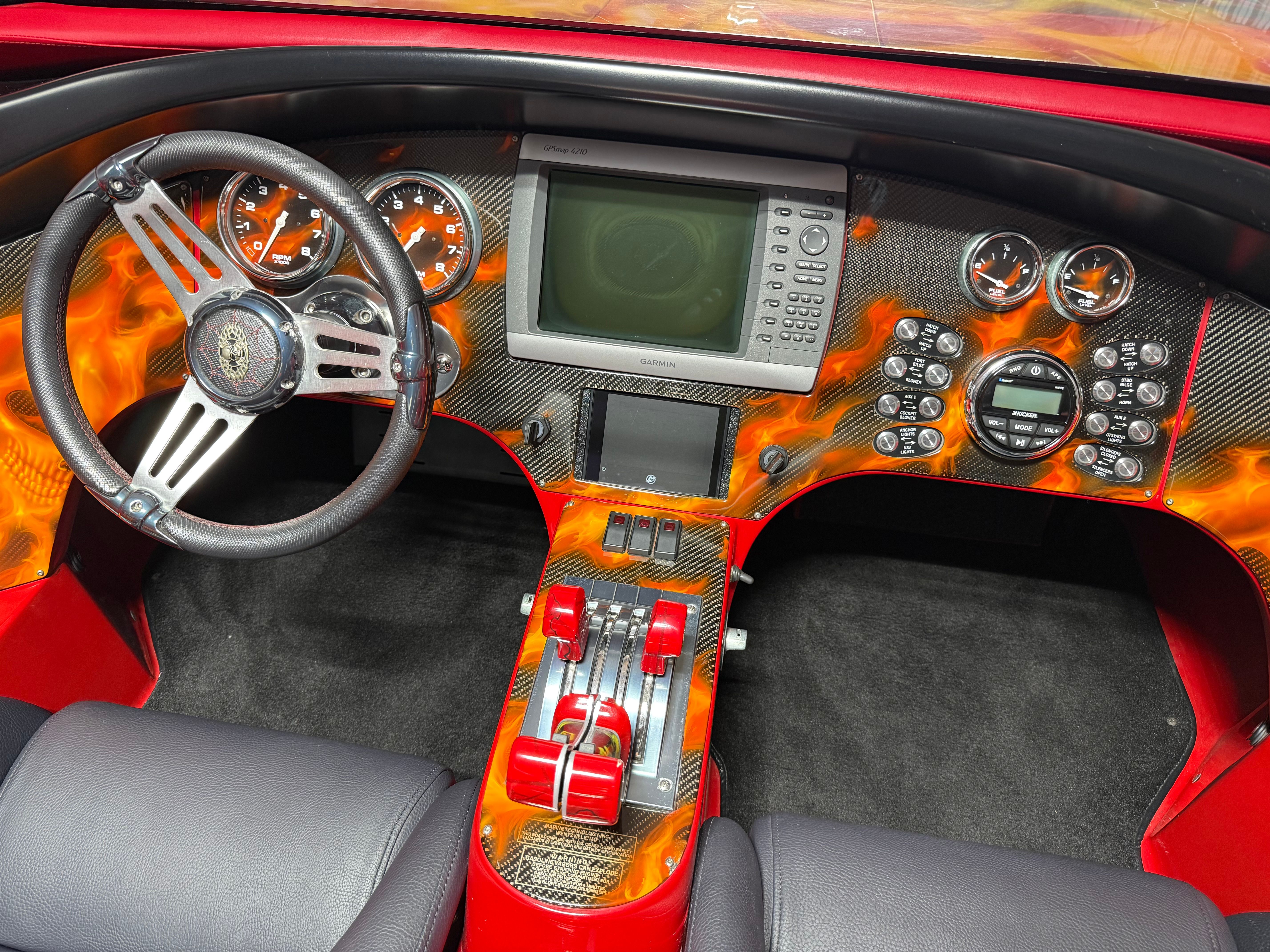 The image shows the cockpit of a 2010 MTI CAT with a striking, fiery dashboard.