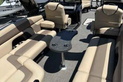 Luxurious 2025 SunCatcher Amara boat interior with beige seating and central table.