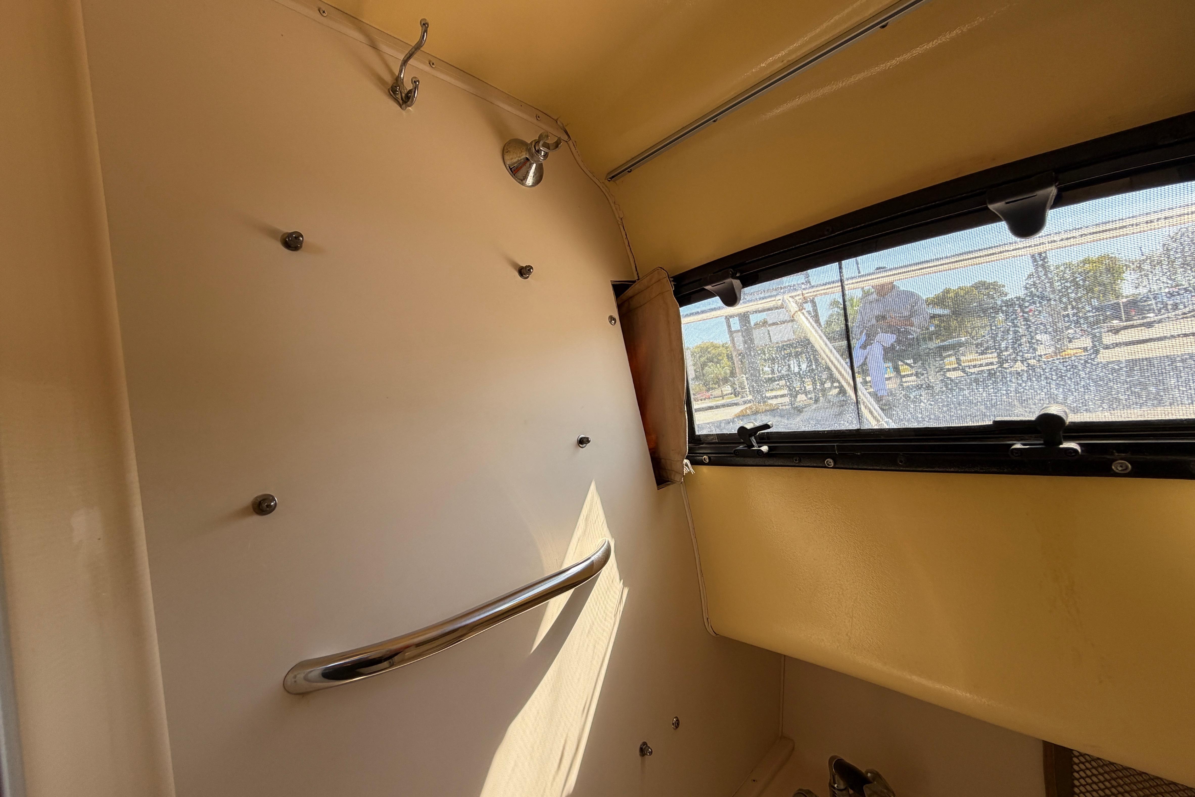 Interior view of a 2006 Grady-White Sailfish 282 boat cabin with window and handrail.