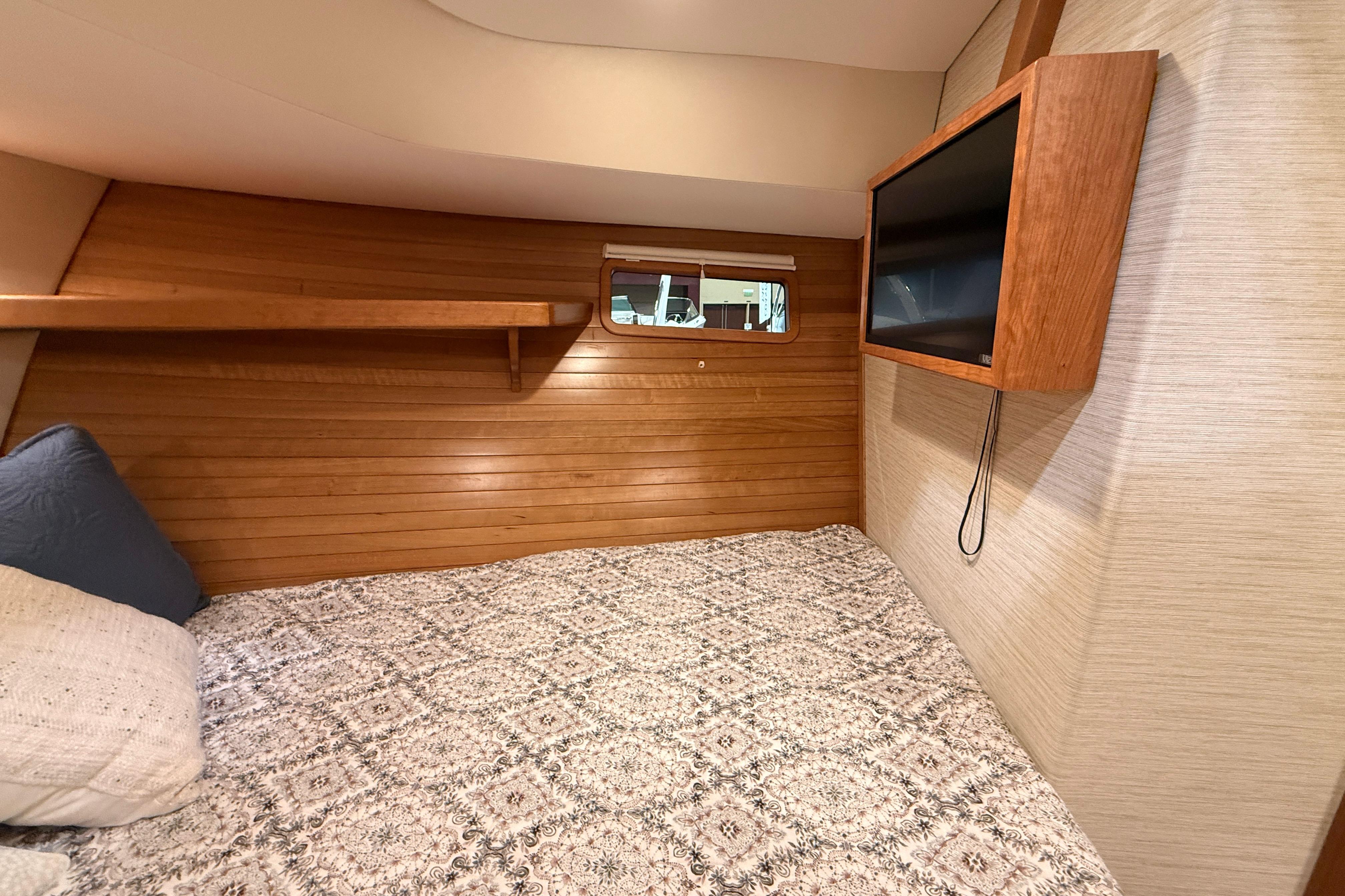 Cozy cabin interior of 2026 MJM 38R with wood paneling and mounted TV.