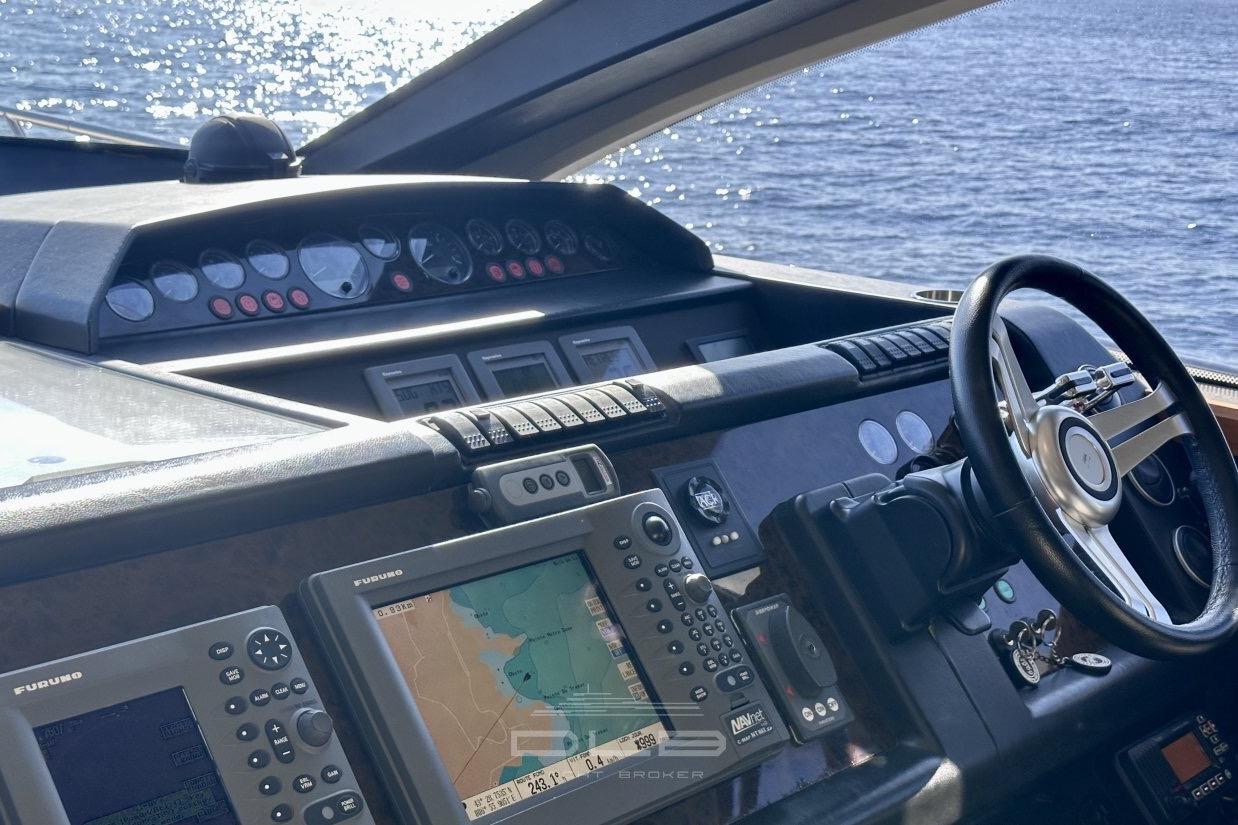 Control panel of a 2006 Princess V70 yacht with navigation equipment and steering wheel.