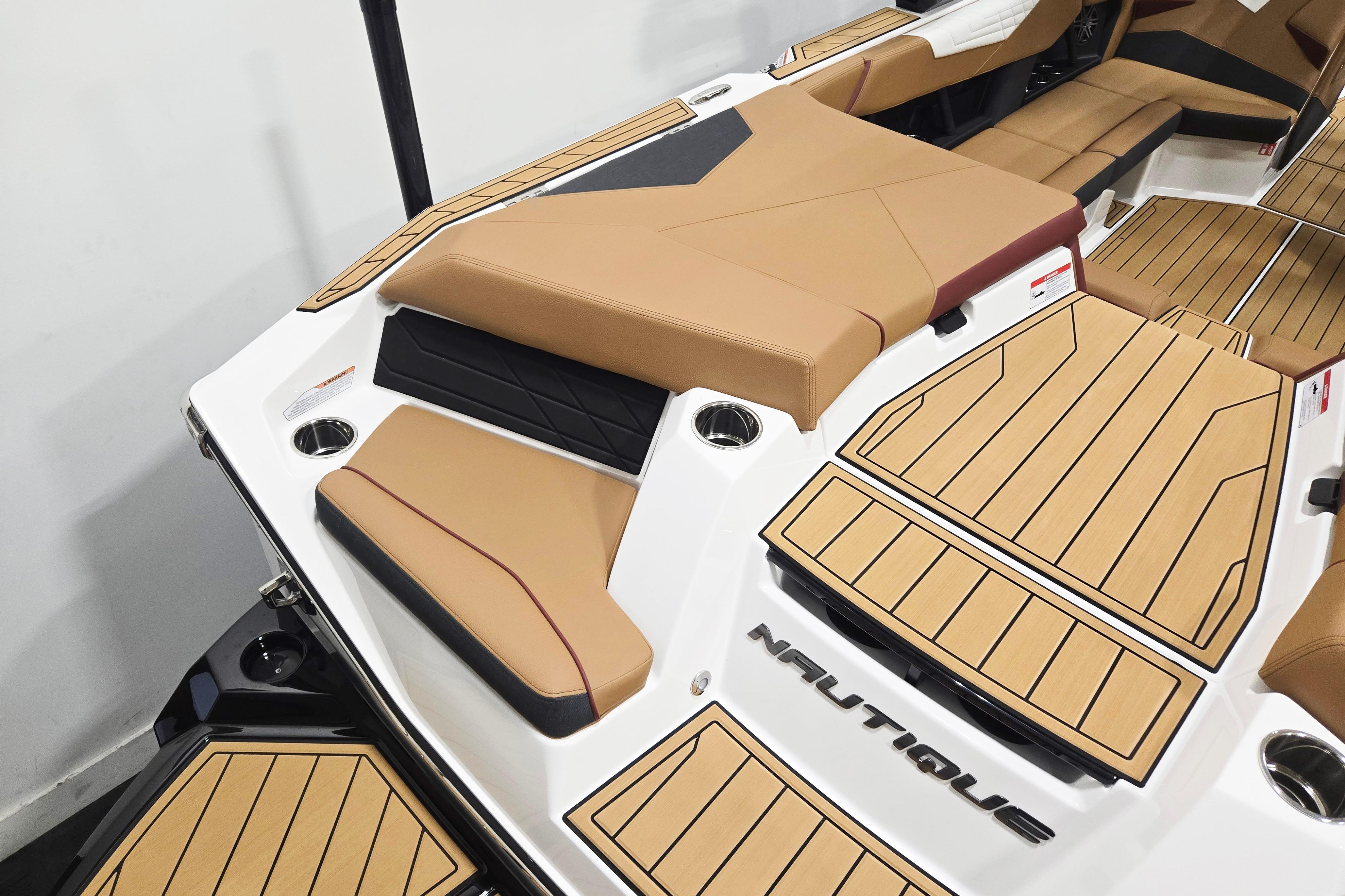 2026 Nautique Super Air Nautique S23 boat interior with tan seating and teak-style flooring.