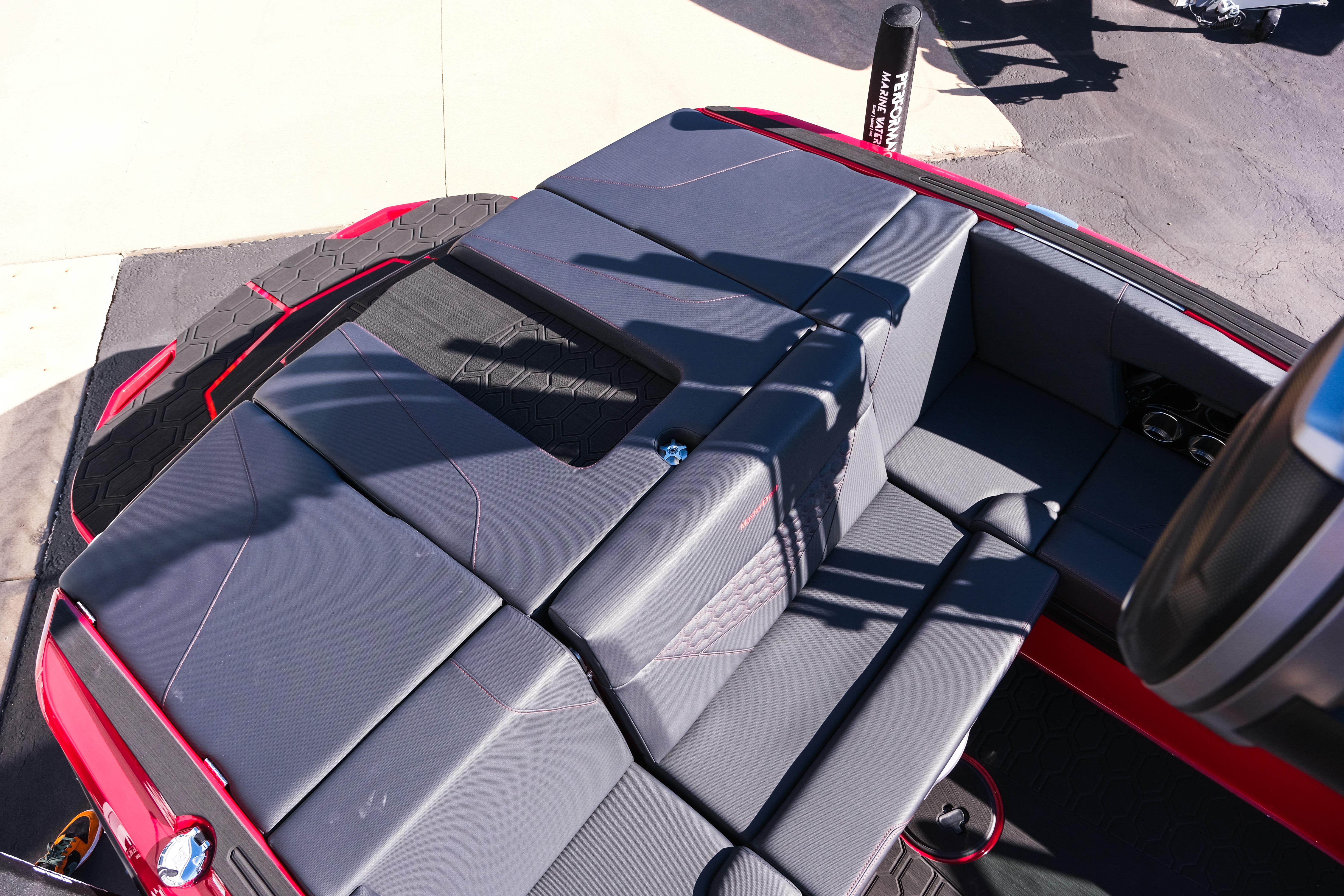 2026 MasterCraft NXT22 boat interior with sleek gray seating and red accents.