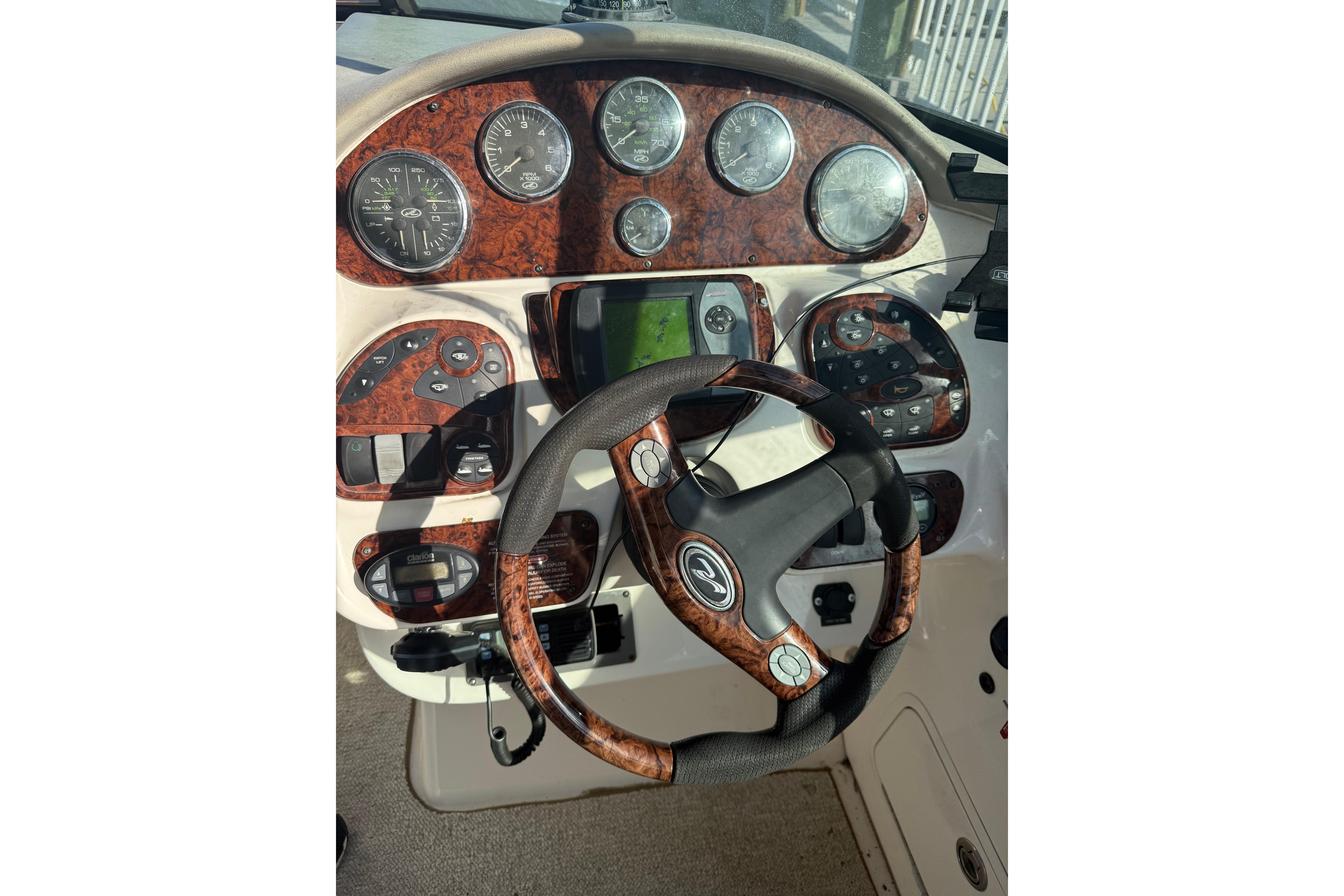2005 Sea Ray 290 SLX dashboard with wood accents and steering wheel.