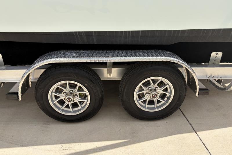 Trailer wheels of a 2024 Key West 239 FS boat on pavement.