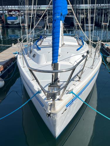 1980 Catalina 30 sailboat docked in marina, featuring blue sail cover and white deck.