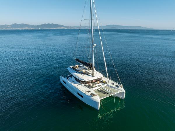 2025 Lagoon 43 catamaran sailing on calm blue ocean waters.