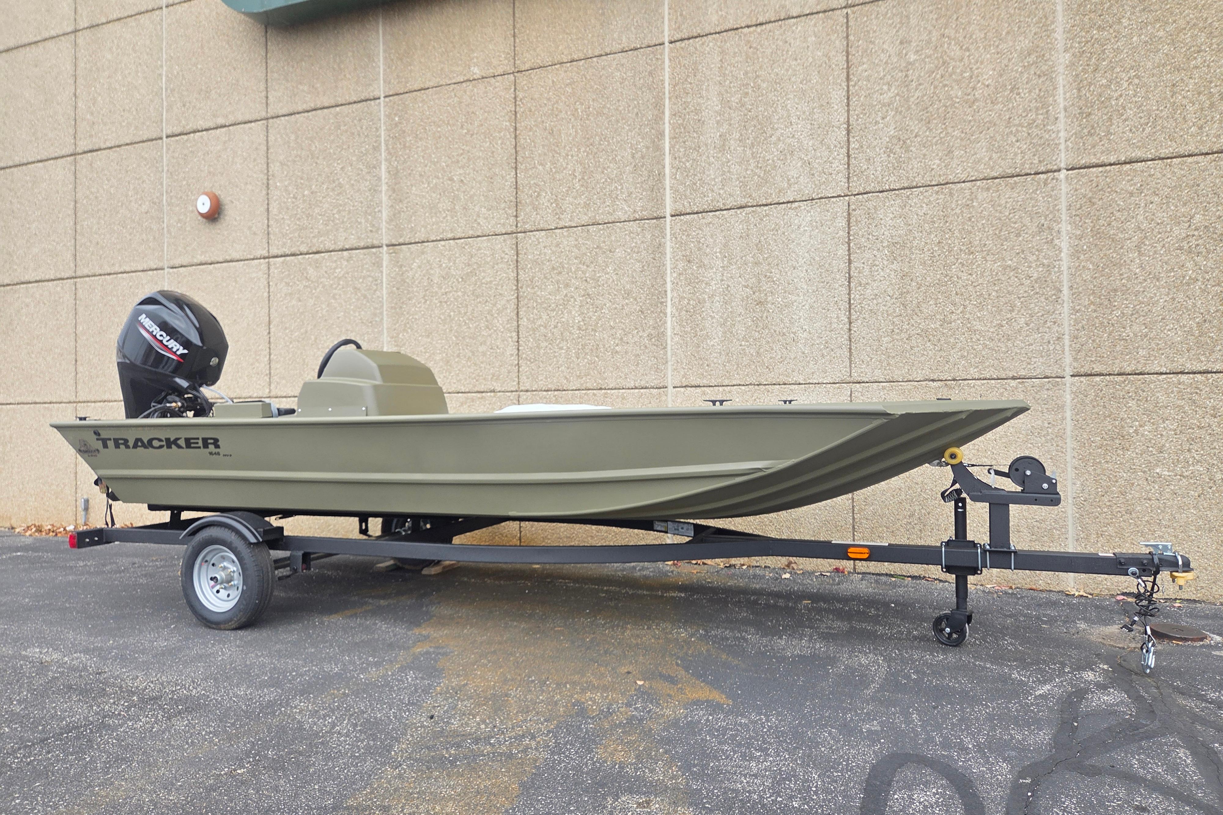 2026 Tracker Grizzly 1648 SC boat on trailer, parked against a beige wall.