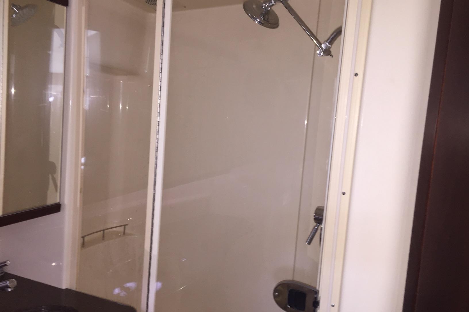 Shower area in 2001 Sea Ray 410 Sundancer yacht, featuring glass door and chrome fixtures.