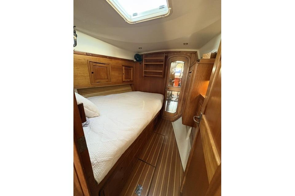 Cozy cabin interior of 2002 Saga 43 yacht with wooden furnishings and skylight.
