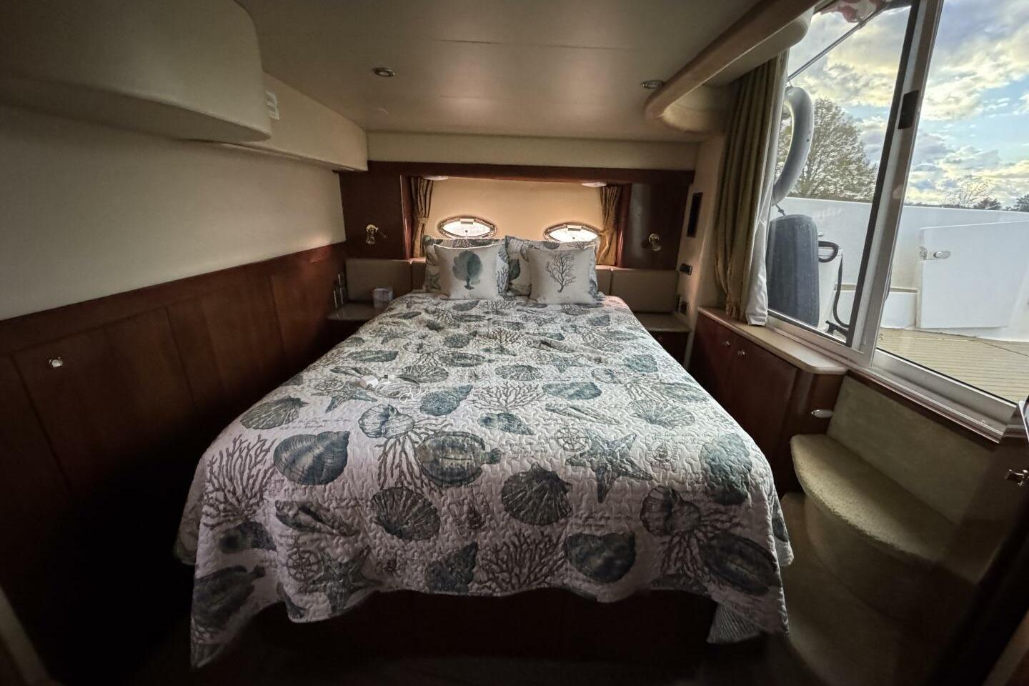 Luxurious bedroom interior of 2008 Meridian 459 Motoryacht with ocean-themed bedding.