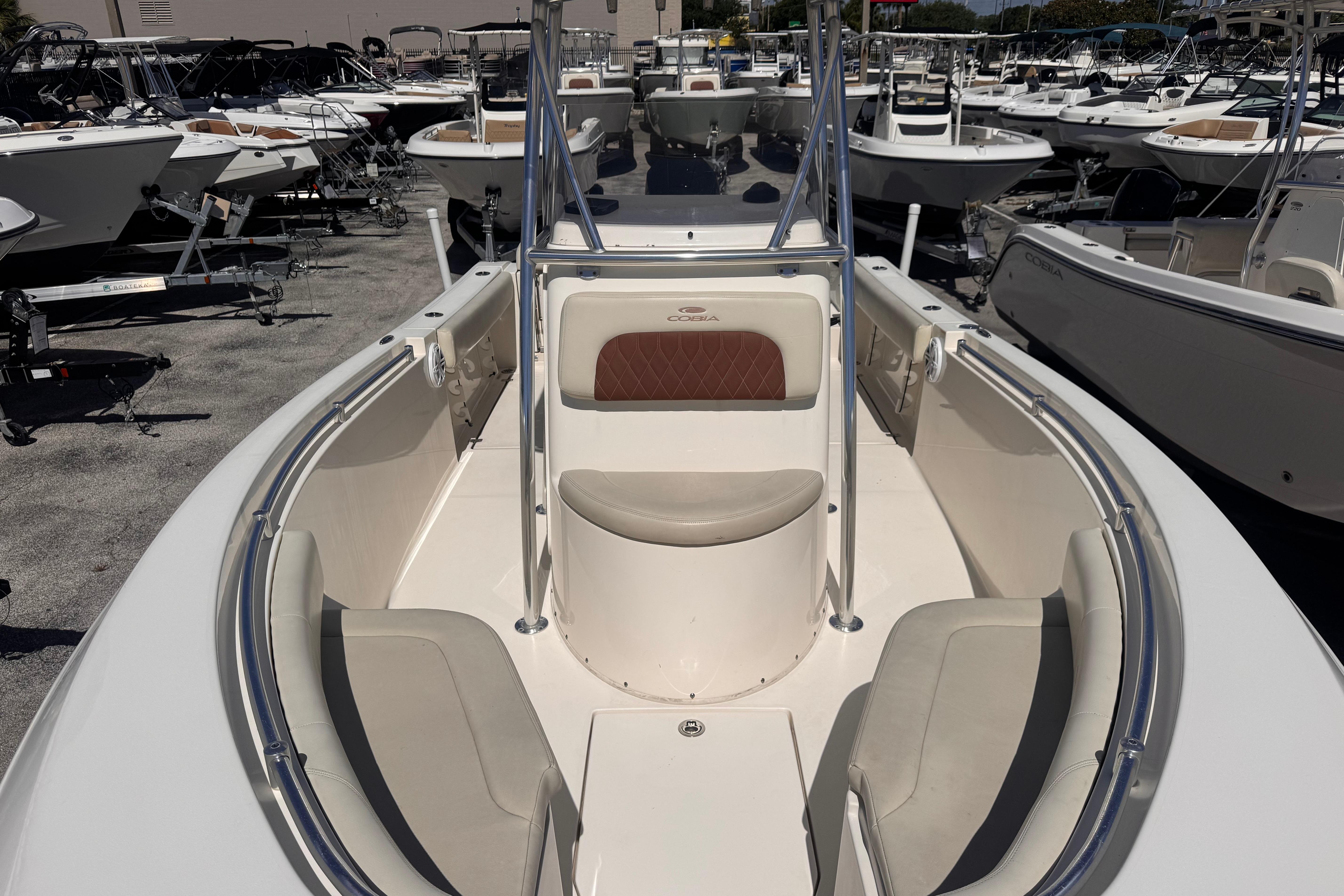 2023 Cobia 237 Center Console boat with spacious seating, displayed in a marina.