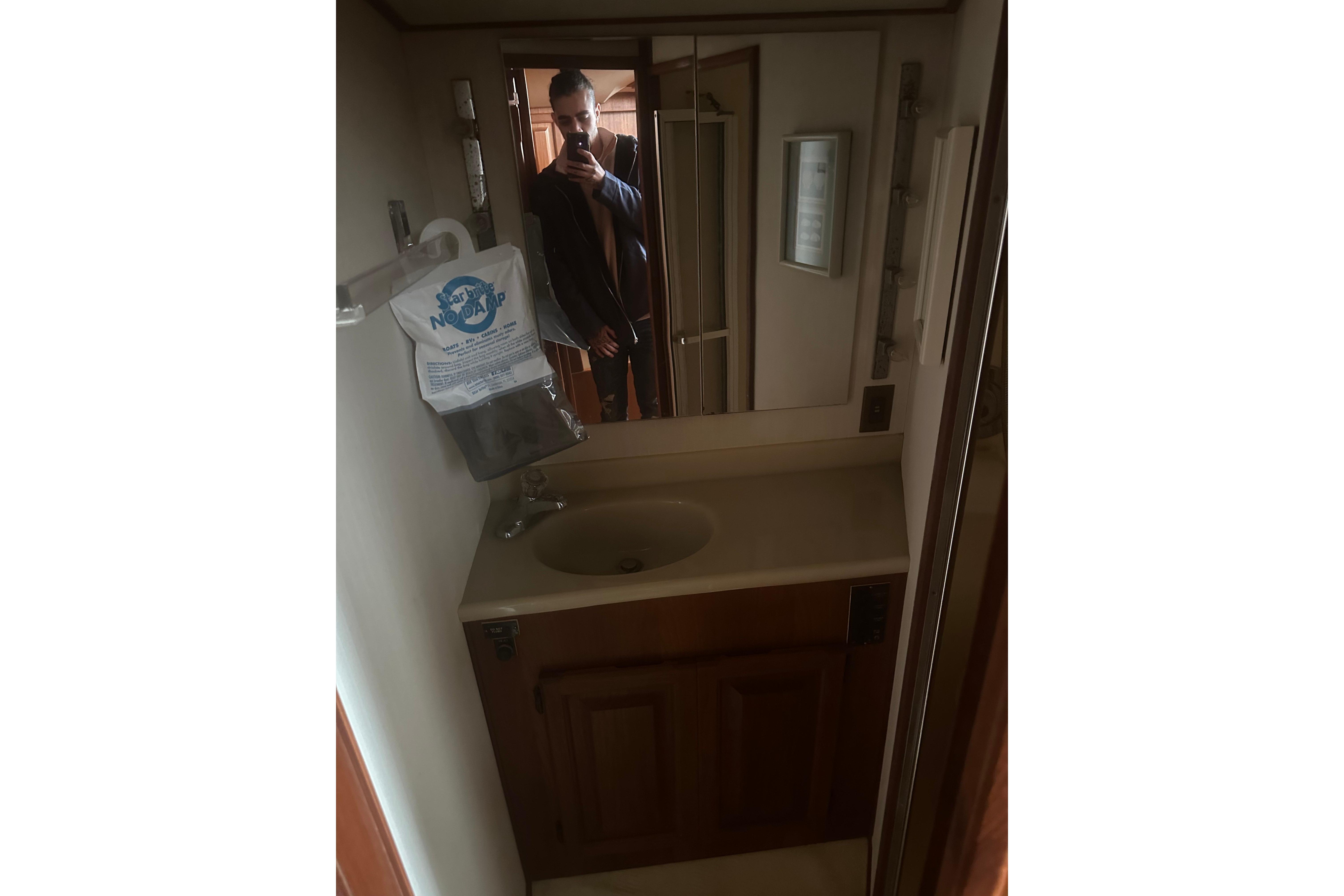 Bathroom interior of 1988 Viking 35 Convertible yacht with sink and mirror.