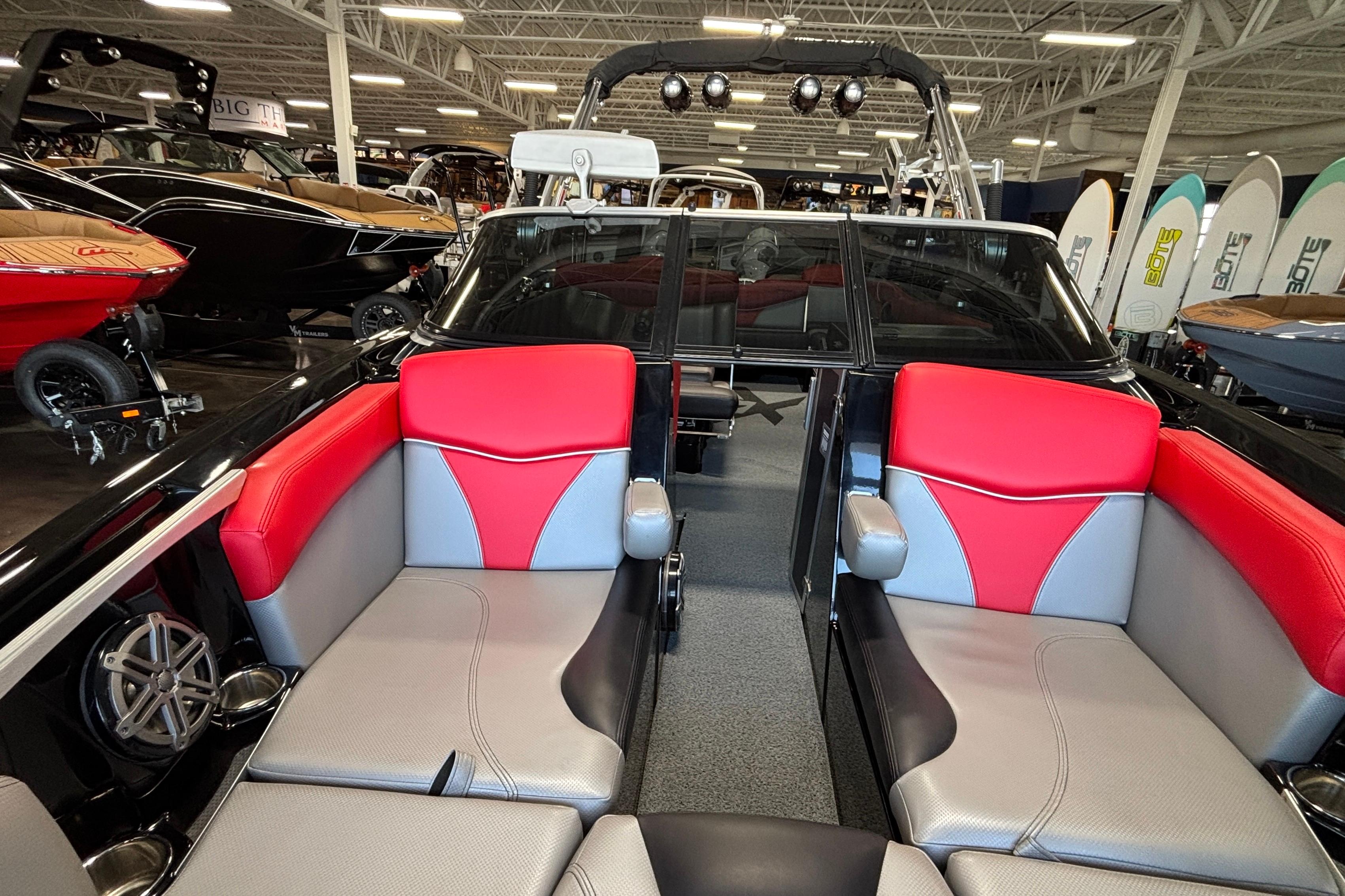 2017 MasterCraft X46 boat interior with red and gray seating in showroom.