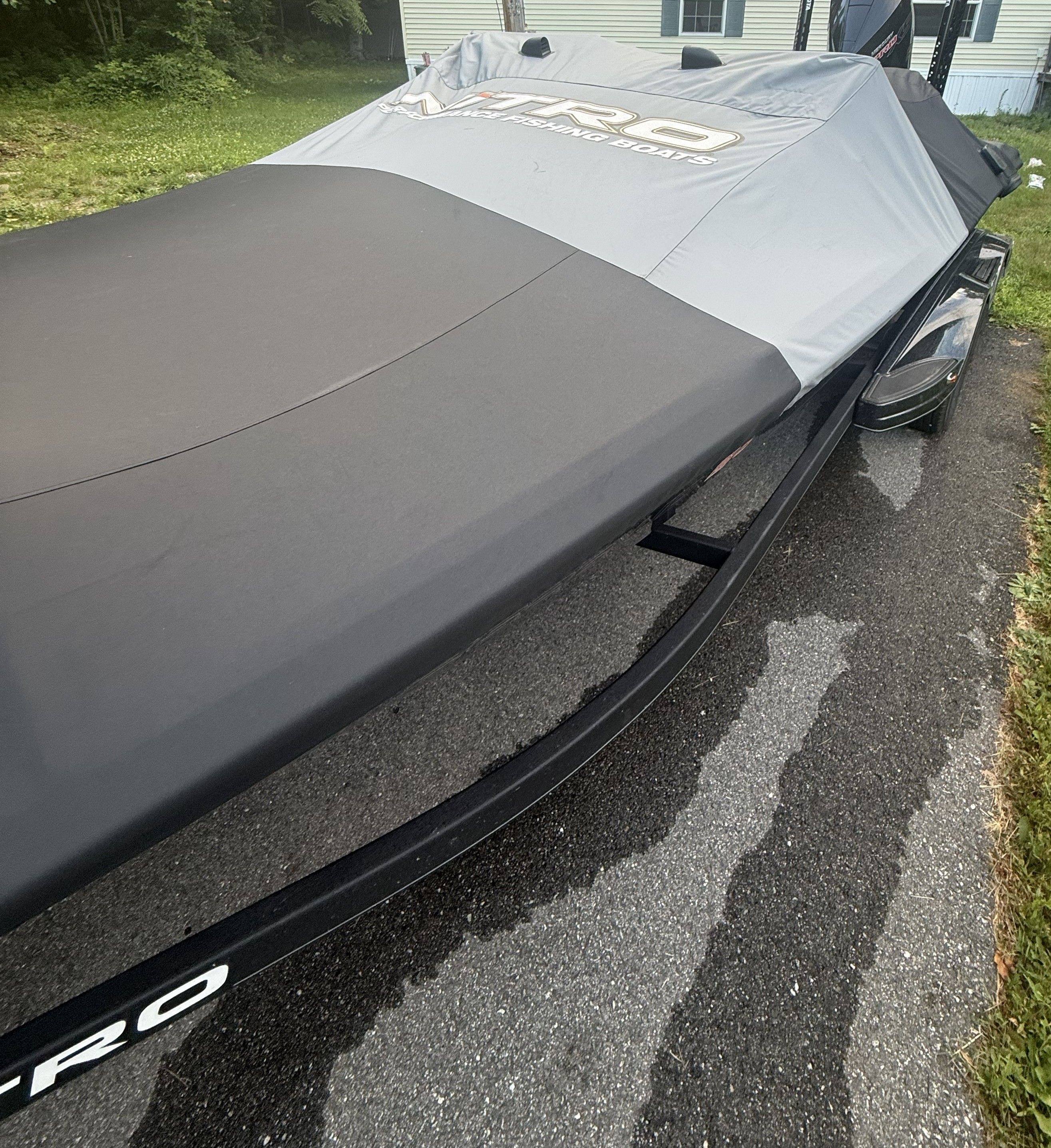 A Nitro Z21 XL Pro boat with a gray cover on a trailer.
