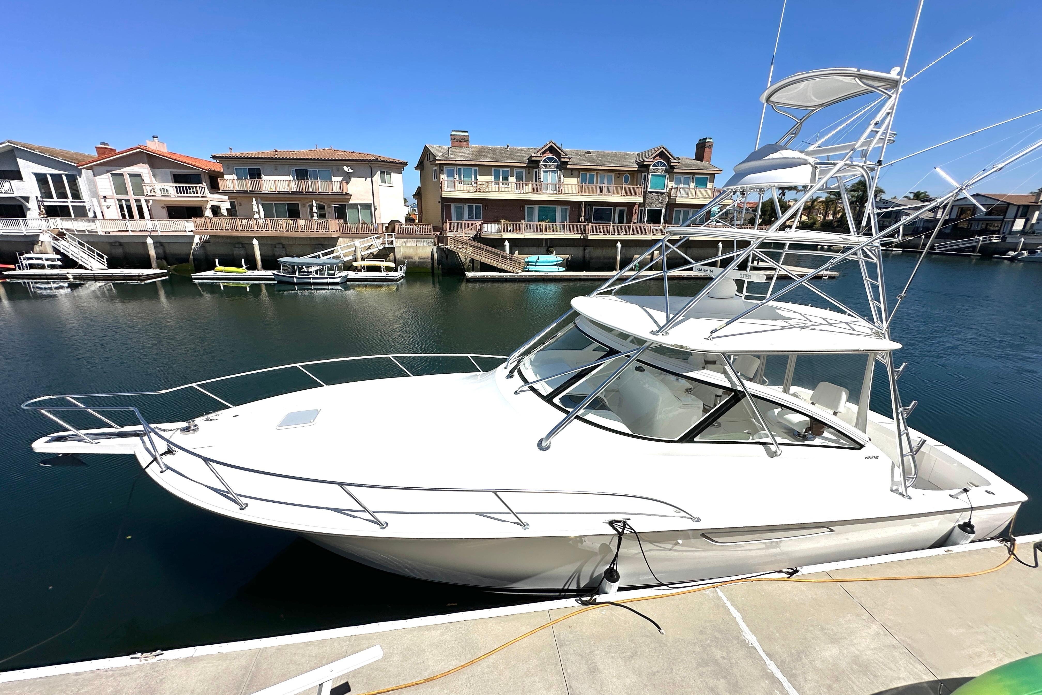 2012 Viking 42 Open yacht docked in a scenic waterfront marina.